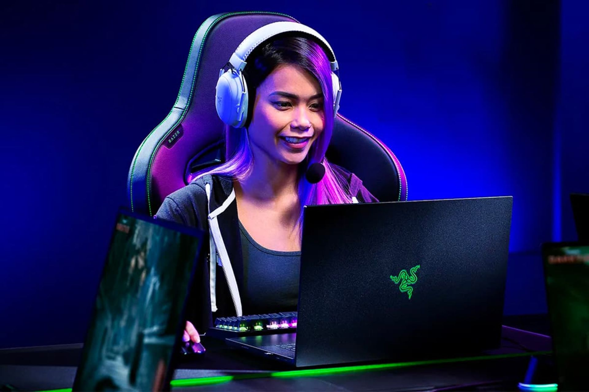 دختر گیمر شاد در حال کار با لپ تاپ ریزر بلید ۲۰۲۴