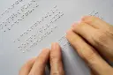 فردی درحال خواندن خط بریل