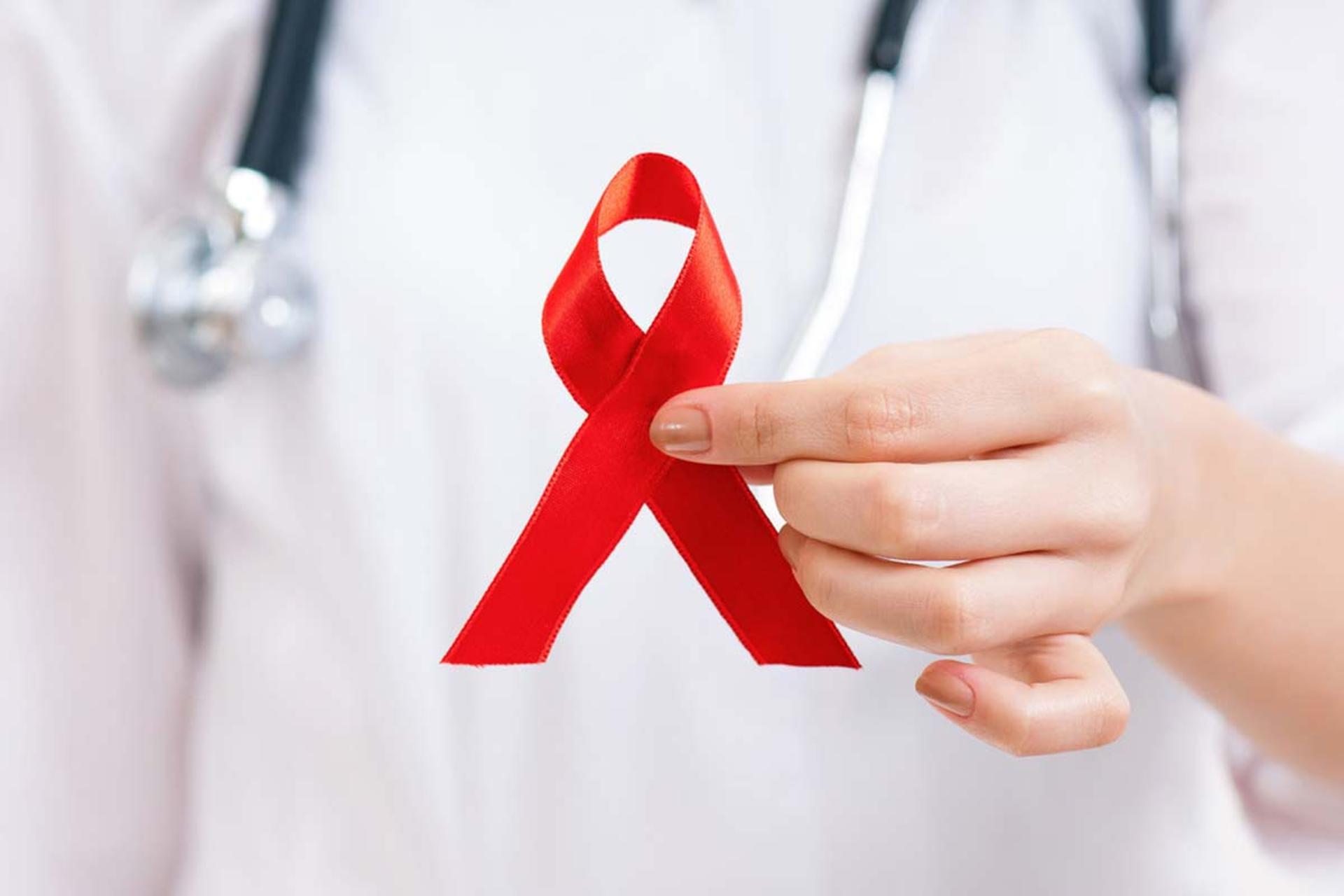 روبان قرمز در دستان پزشک به عنوان نماد روز جهانی ایدز