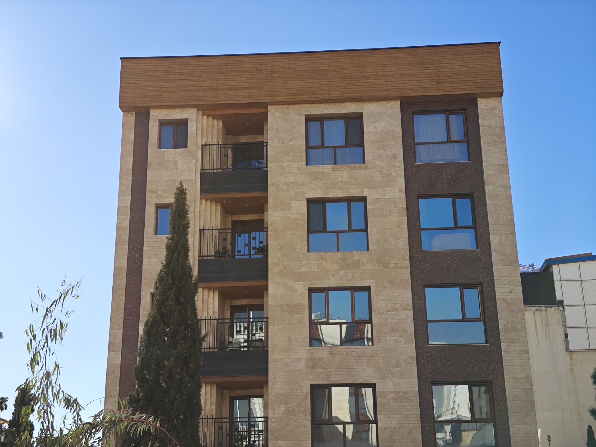 نمای ساختمانی چهار طبقه با رنگ کرمی و قهوه‌ای