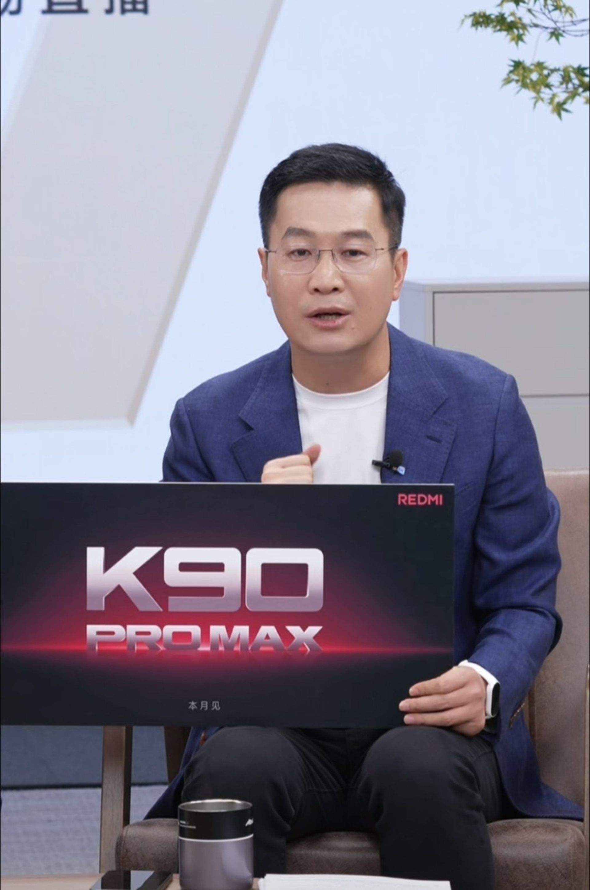 یک مرد جوان در حال نمایش تابلویی با لوگو K90 Pro Max