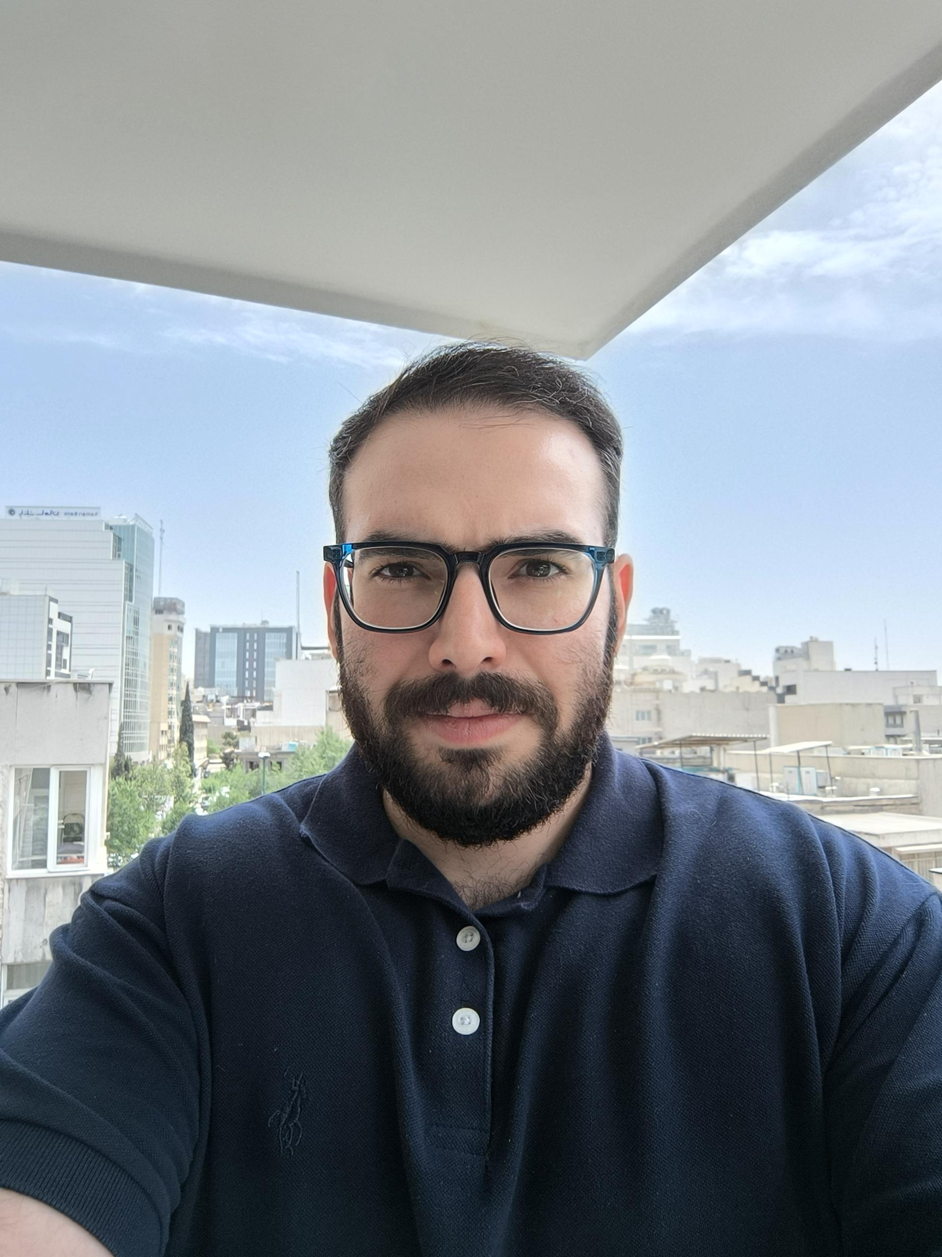نمونه عکس ردمی نوت ۱۳ پرو پلاس با دوربین سلفی از یک مرد جوان با پس زمینه آسمان و چندین ساختمان