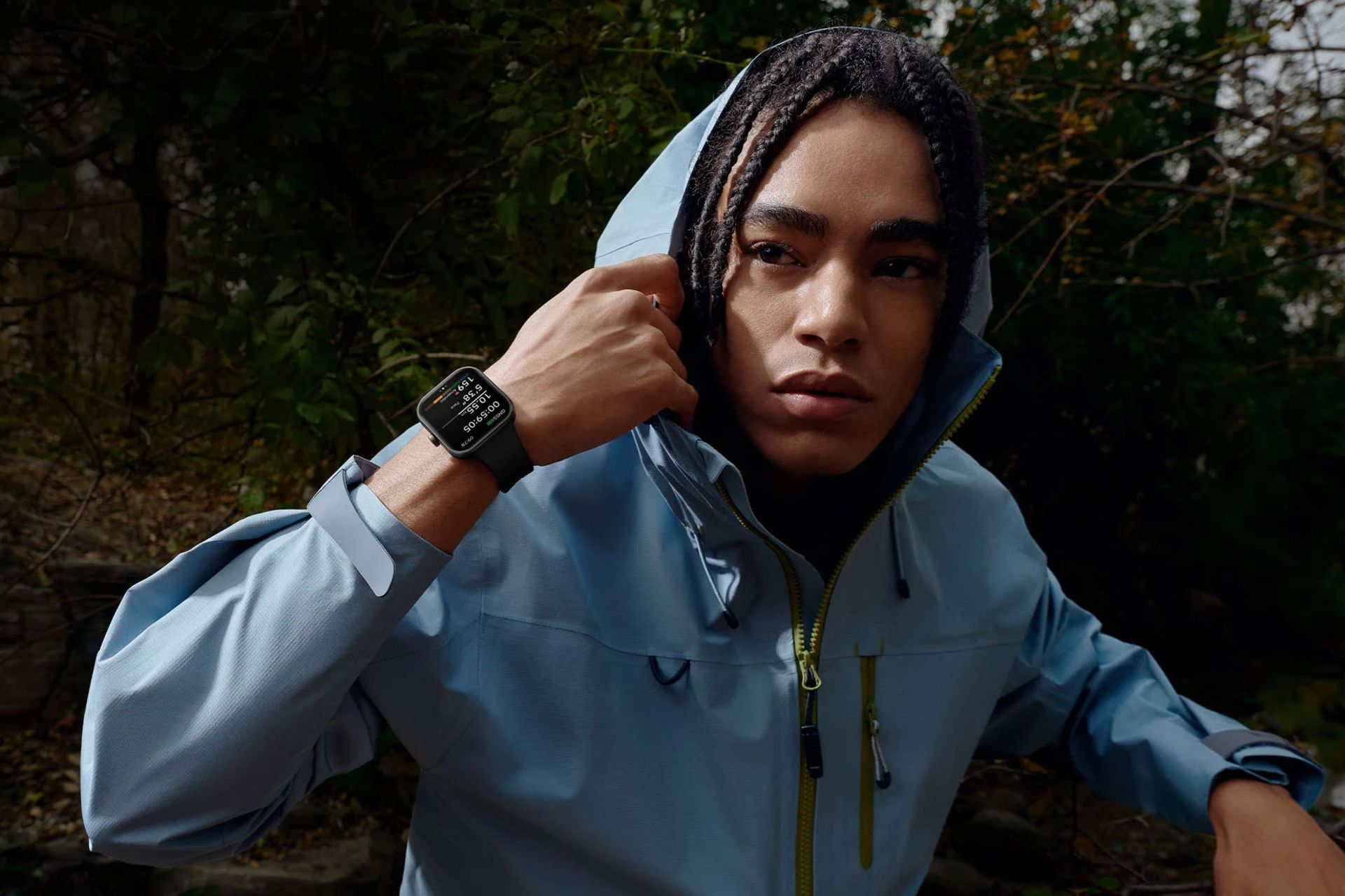 ساعت هوشمند ردمی واچ ۵ در دست یک پسر جوان سیاه پوست با سویشرت آبی