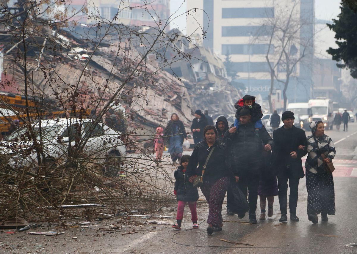 Pedestrians next to the collapsed building after the earthquake in Kahramanmaras, Turkey