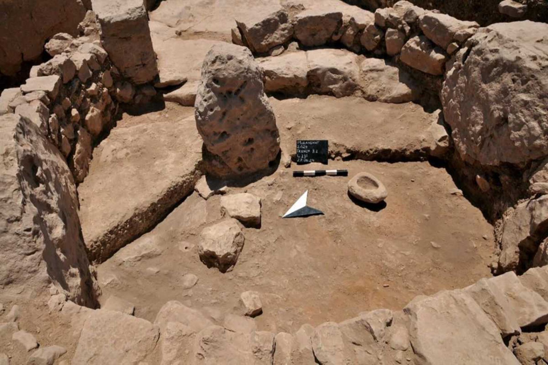 یکی از سنگ‌های ایستاده در موریقات، که درون یک محوطه دیوارکشی شده قرار دارد و یک ملات سنگ آهک بزرگ در نزدیکی آن قرار دارد (راست).