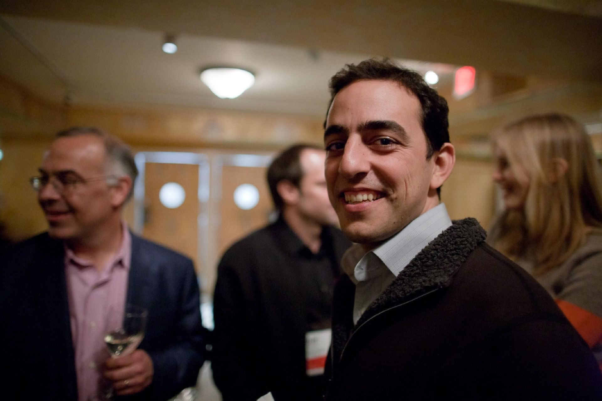 چهره‌ی یک مرد جوان در میان چند نفر