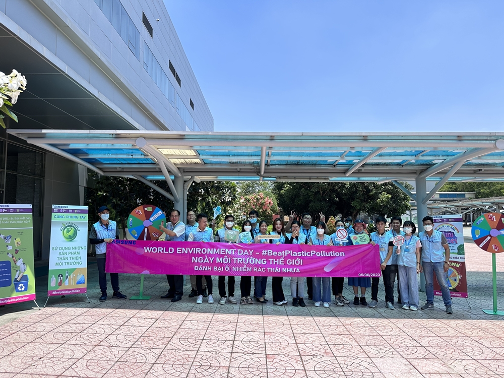 چند نفر در حال حمل بنر در مقابل کارخانه ای از سامسونگ