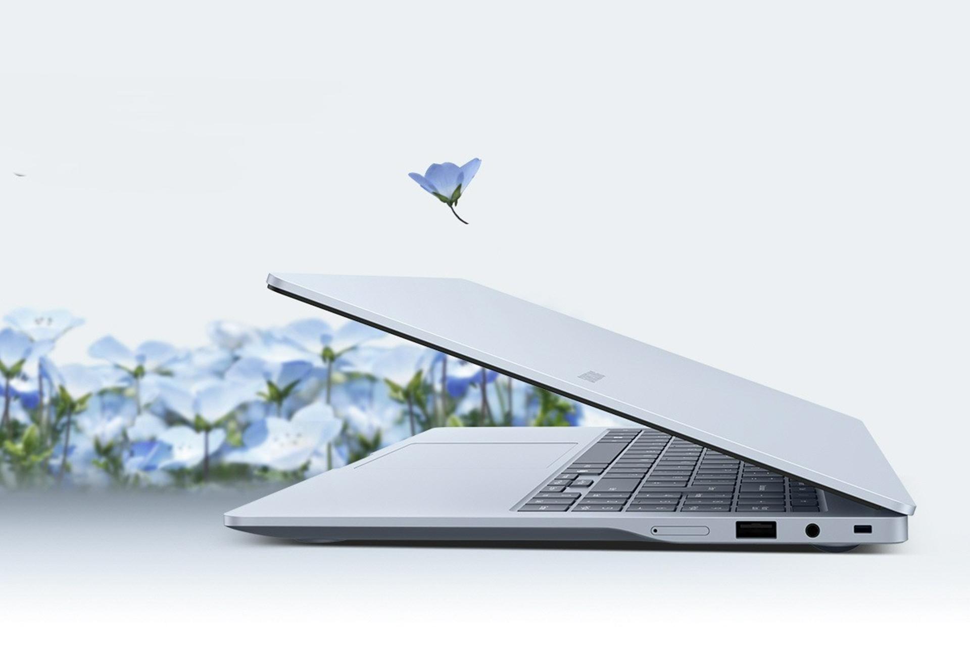 نمای جانبی لپ‌تاپ گلکسی بوک ۵ اج سامسونگ در حالت نیمه‌باز کنار گل