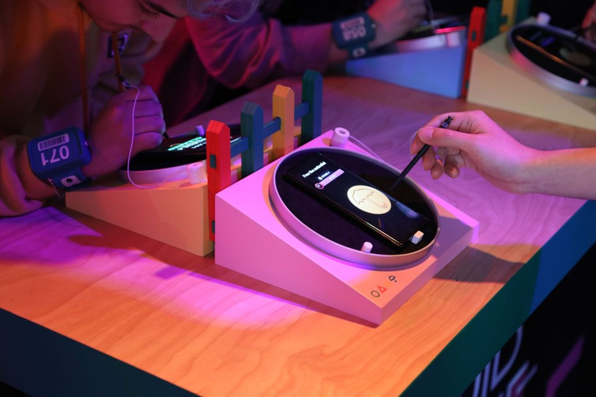 دو نفر در حال کشیدن قلم روی گوشی سامسونگ