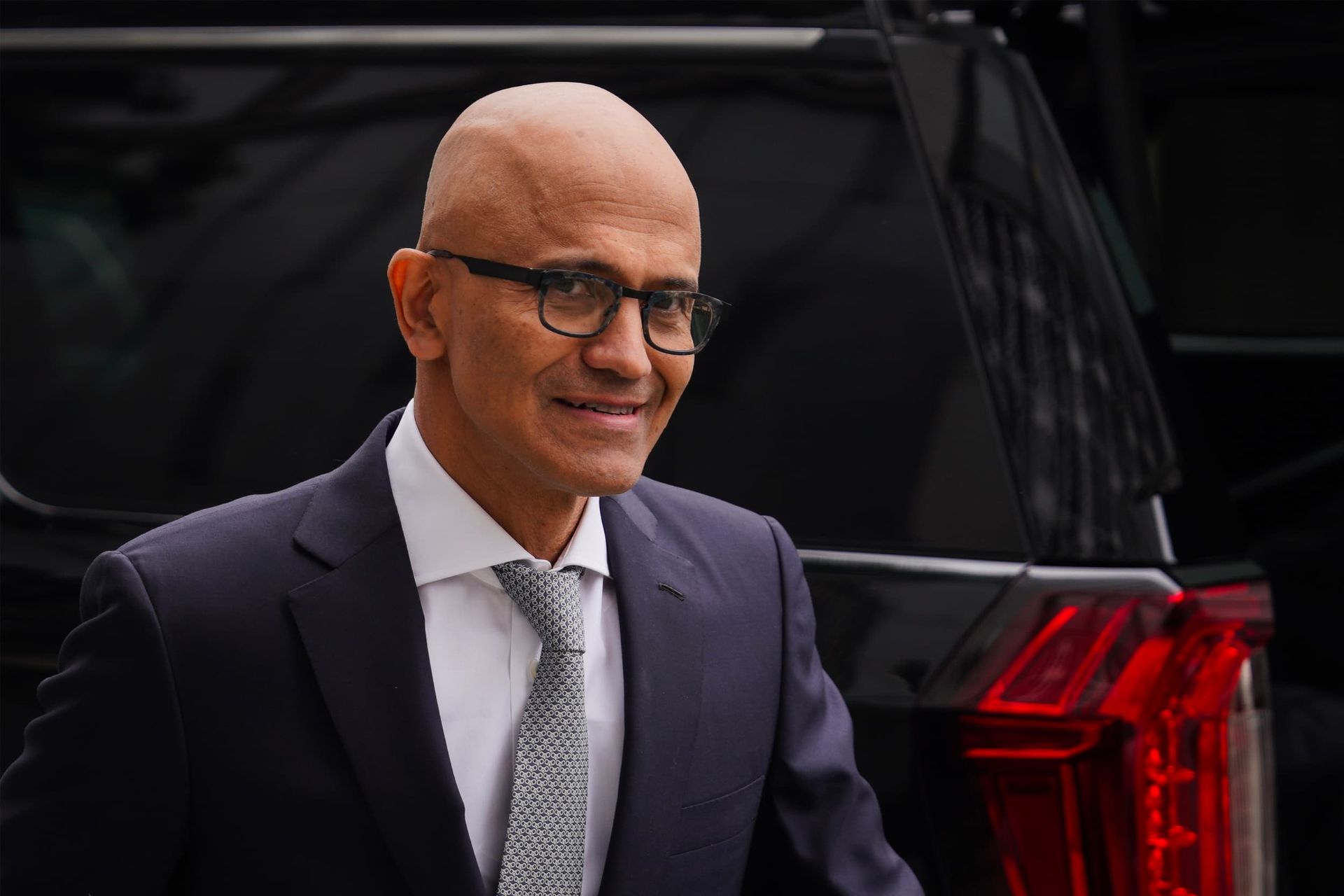 ساتیا نادلا / Satya Nadella با کت شلوار و لبخند جلو ماشین شاسی بلند