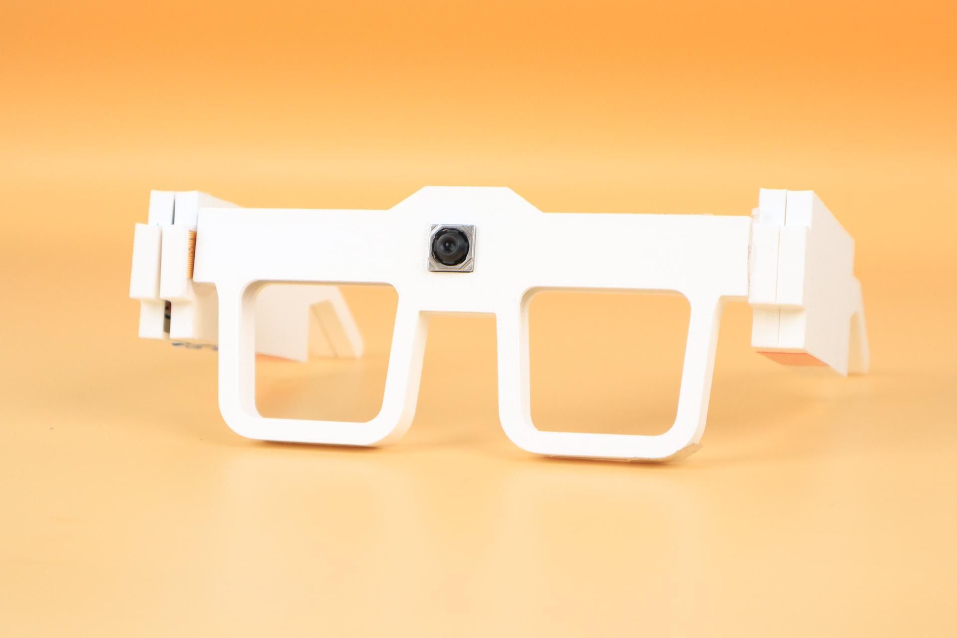 عینک هوشمند سفید روی میز نارنجی