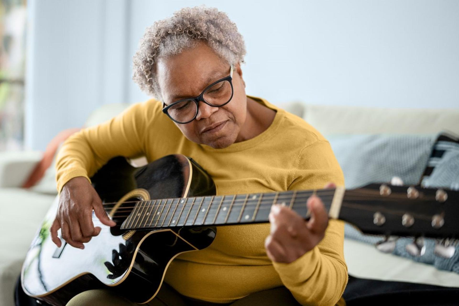 زن سالخورده درحال نواختن گیتار است