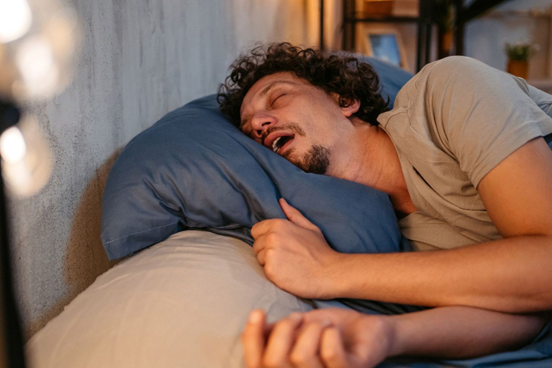 مردی مبتلا به آپنه‌ی انسدادی خواب با خواب مختل شده و تنفس بد روی تخت خوابیده