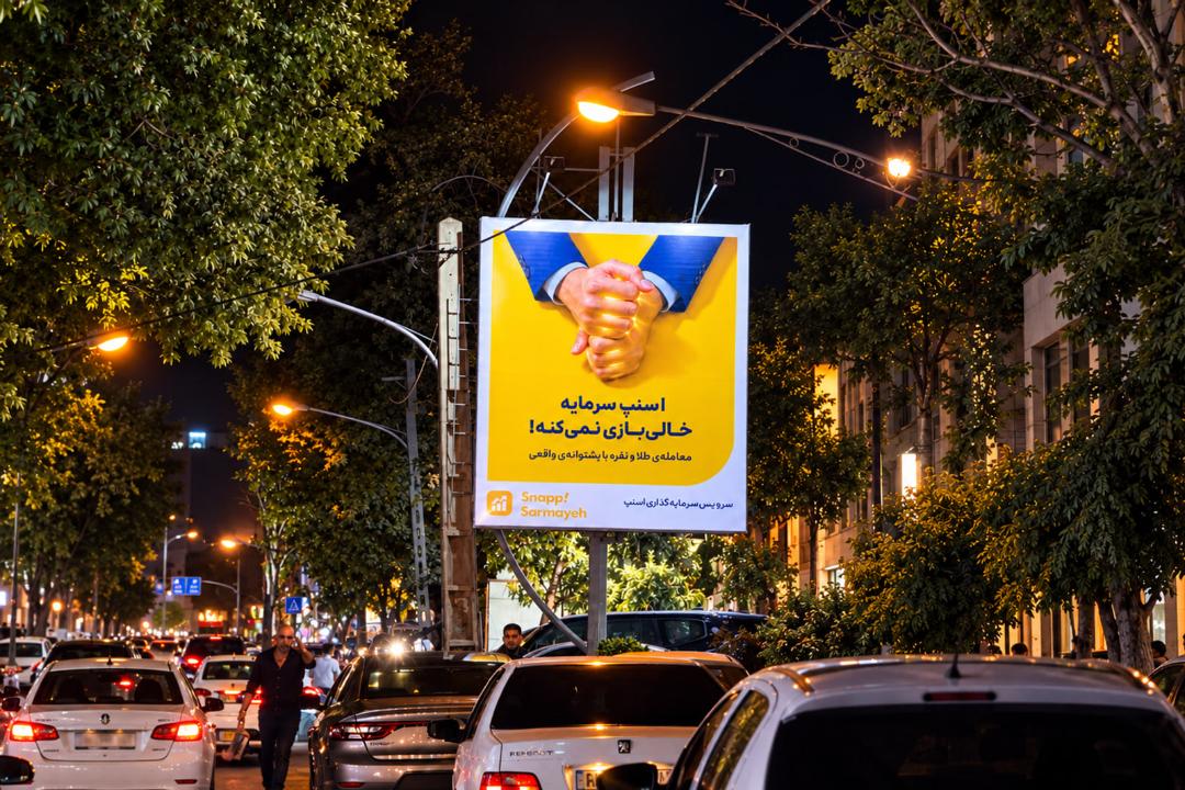 بیلبورد تبلیغاتی اسنپ‌سرمایه (Snapp Sarmayeh) در خیابان در شب