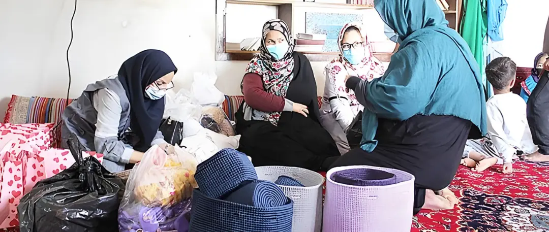 زنان در حال بررسی بسته‌های حمایتی و اقلام مورد نیاز در یک نشست اجتماعی
