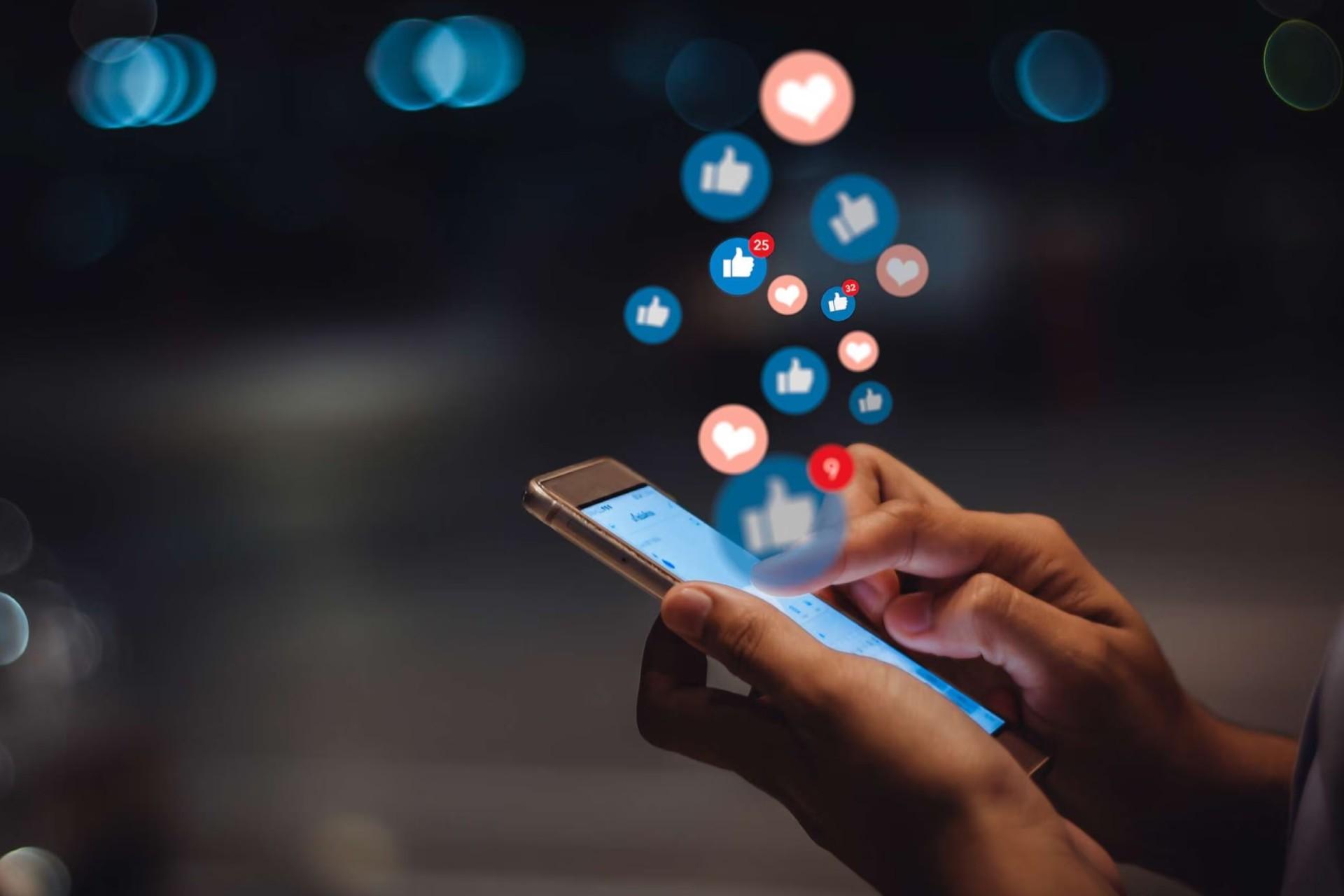 تصویرسازی یک دست گوشی به دست و اعلان‌های شبکه‌های اجتماعی