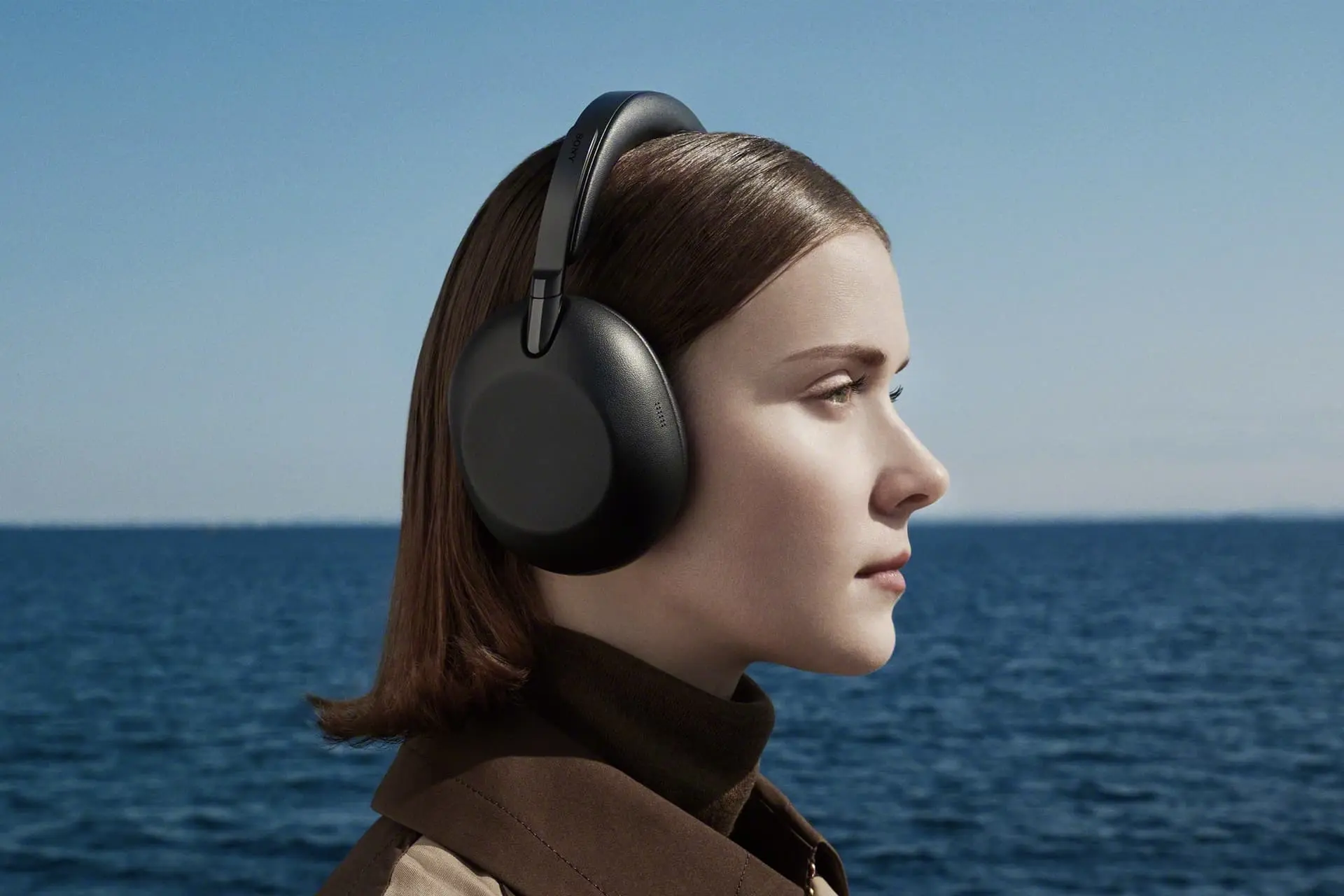 هدفون سونی Sony 1000X the Collexion روی سر یک خانم پس زمینه دریا