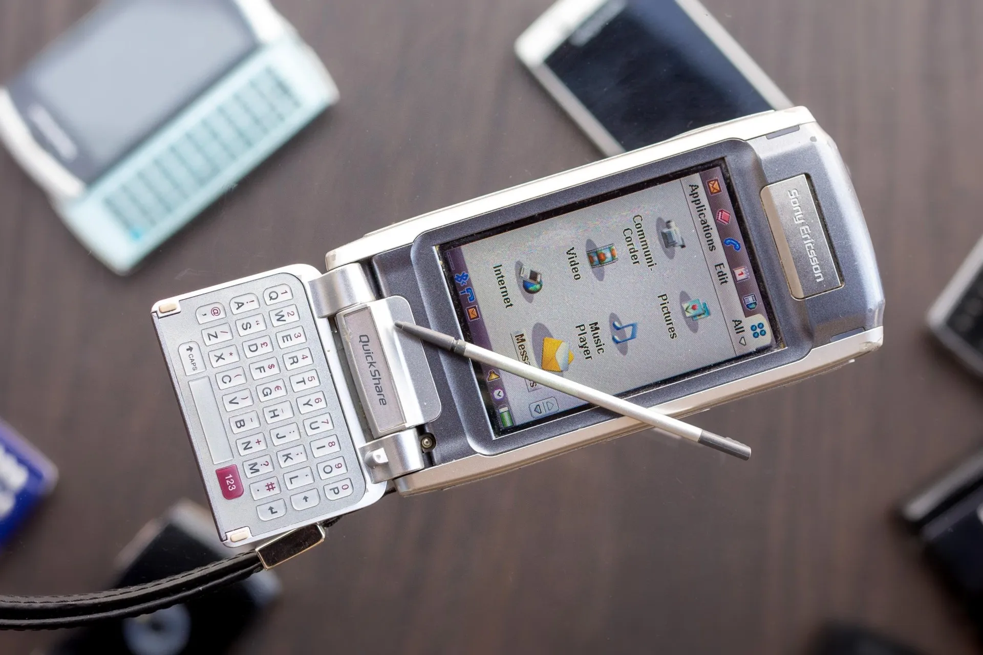 نمای جلو گوشی سونی اریکسون P910 در کنار قلم