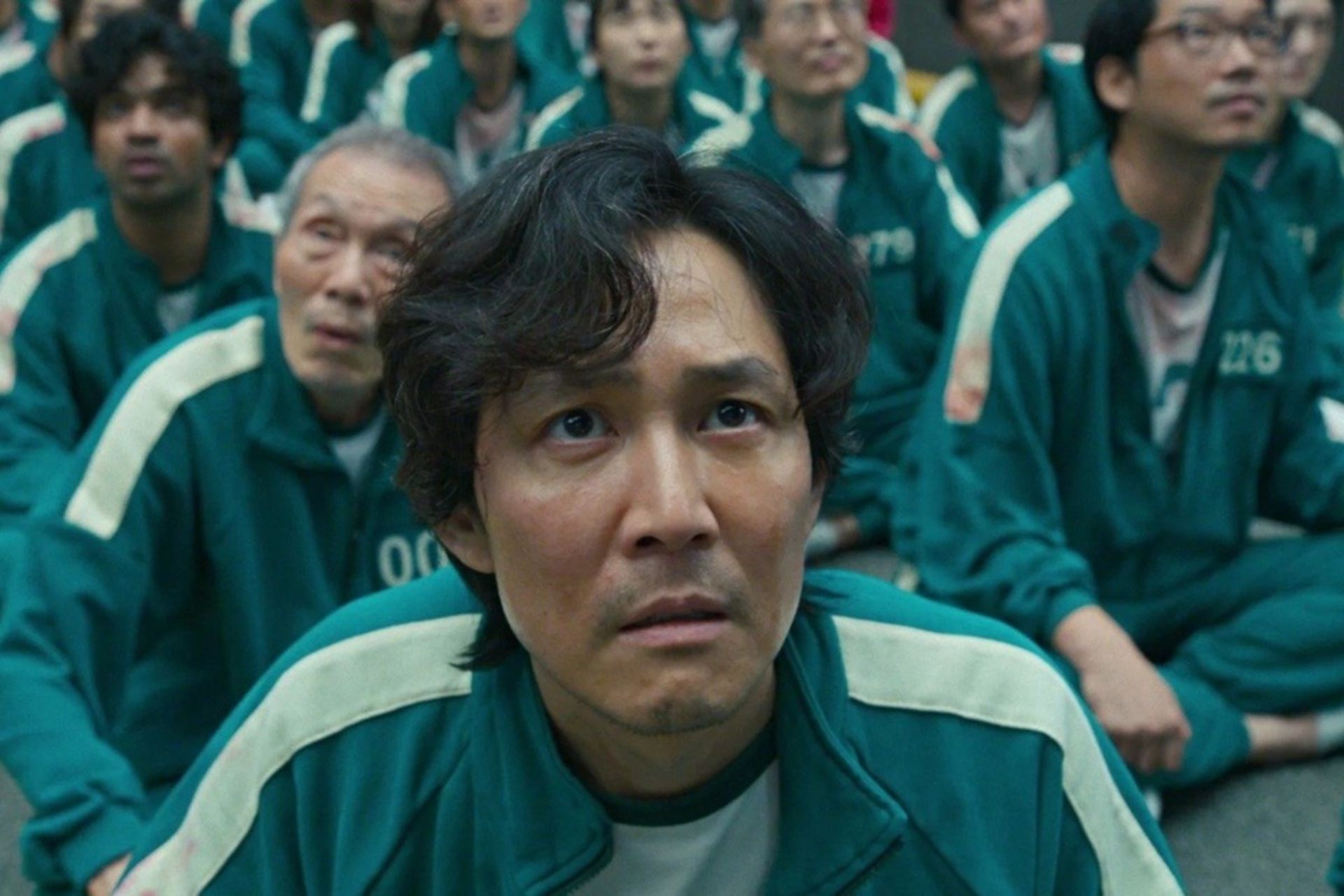 مرد جوان در لباس سبز در حال نگاه نگران به بالا