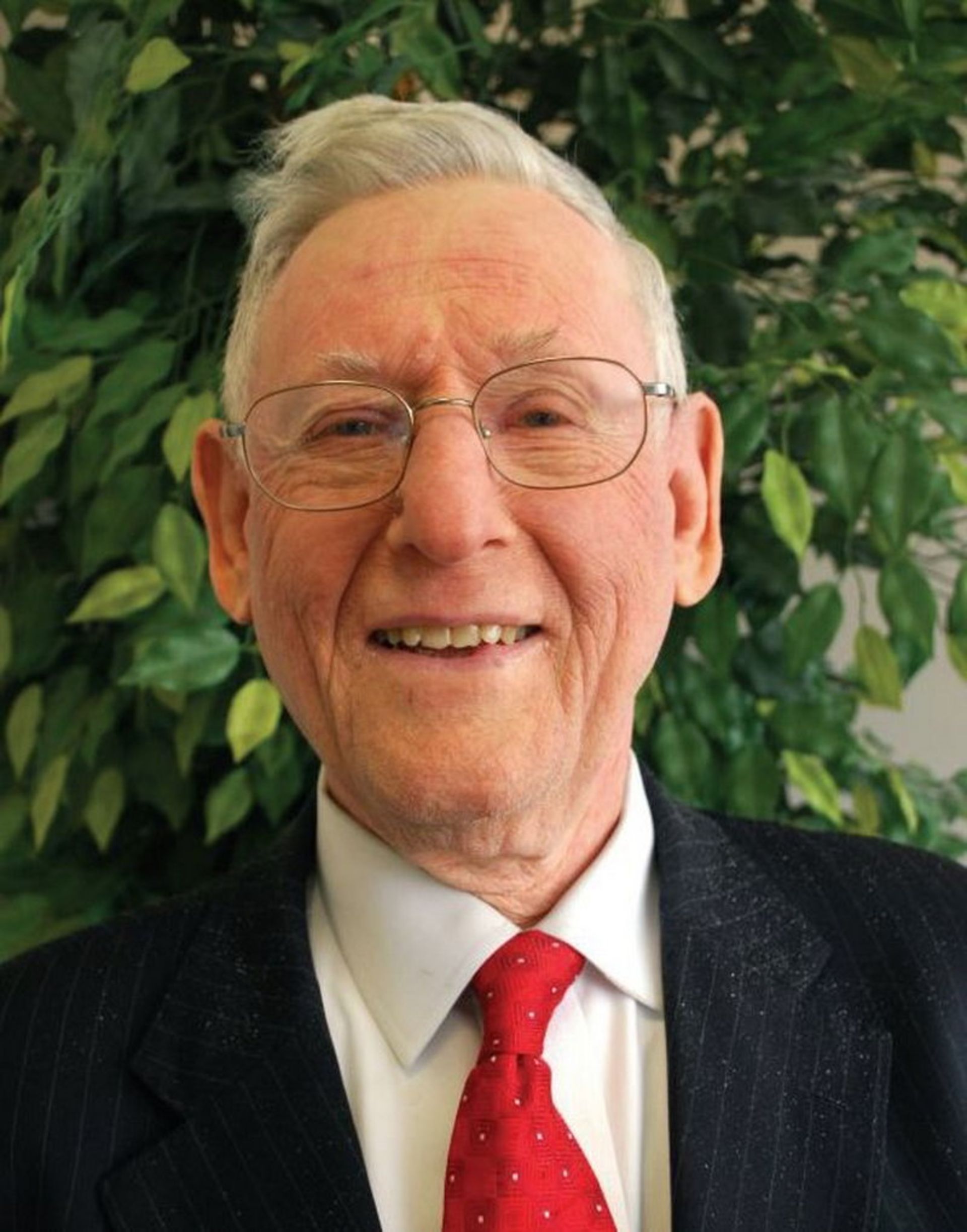 استنلی ریچموند مردی میانسال و مرتب با لبخند و عینک