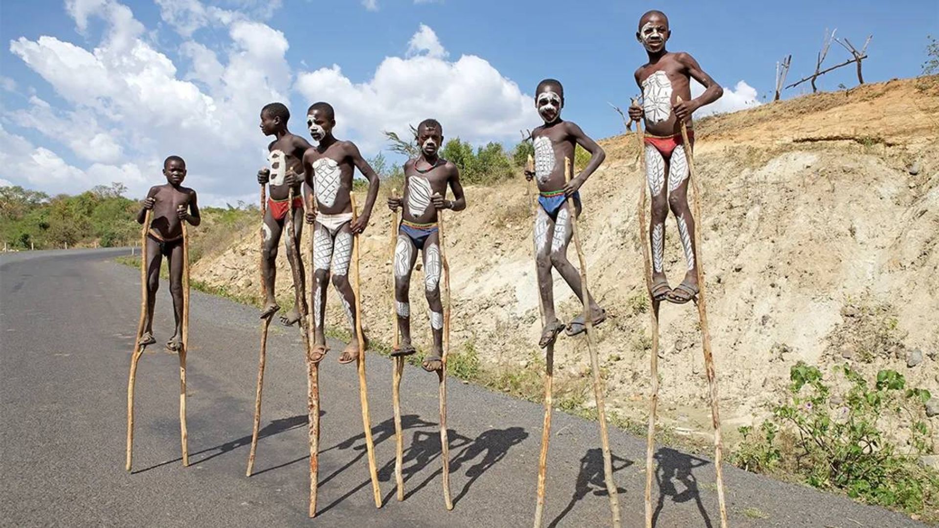بومیان اتیوپی درحال راه رفتن روی پایه چوبی بلند