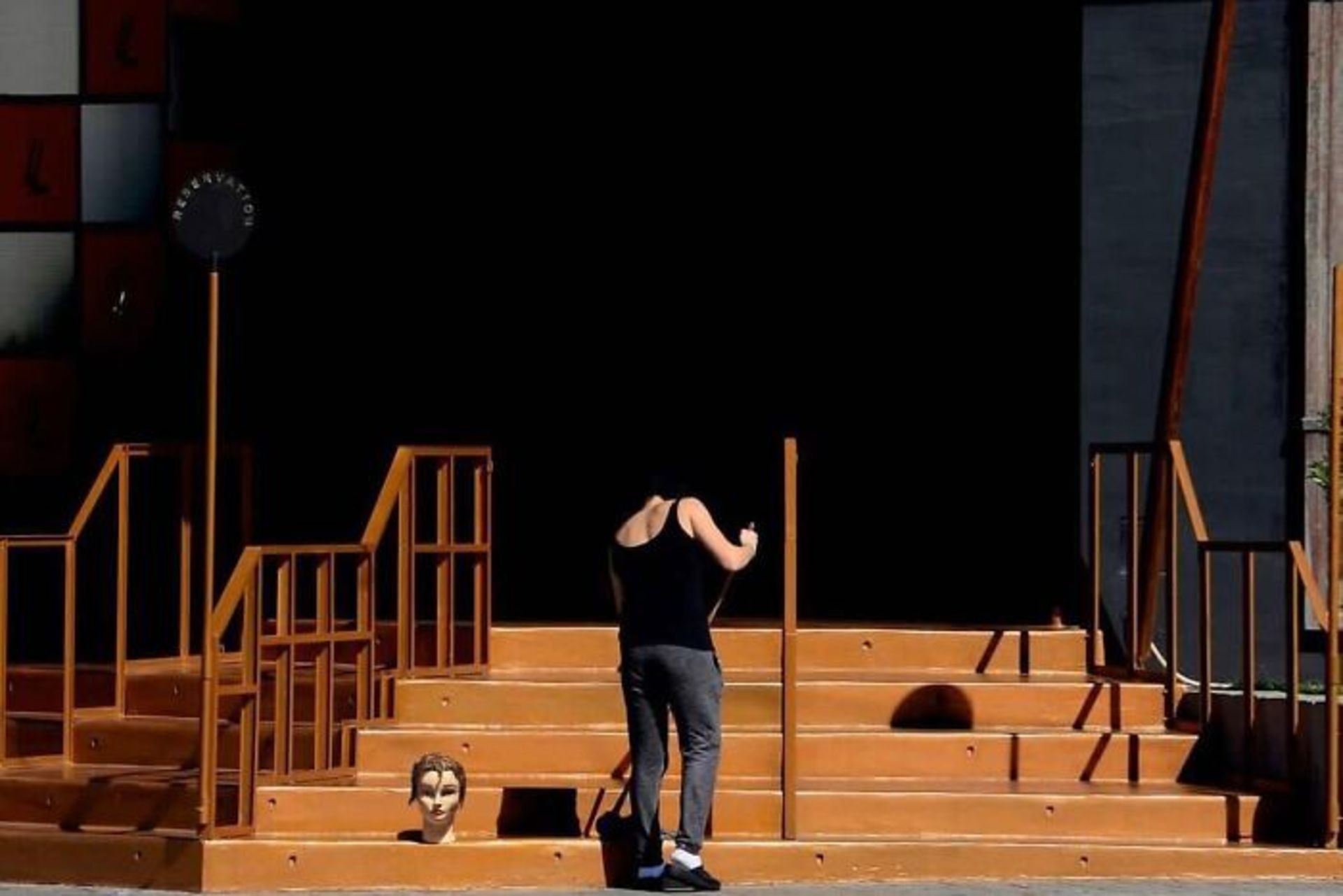 زن در حال تمیز کردن پله ها و کله مانکن روی پله