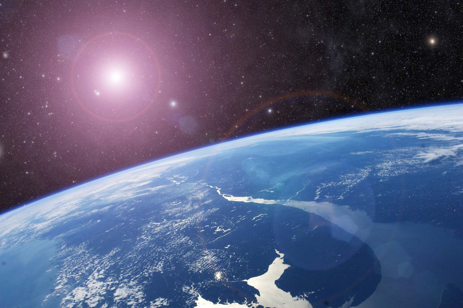 نمای نزدیک از سیاره زمین از فضا و خورشید در پس‌زمینه