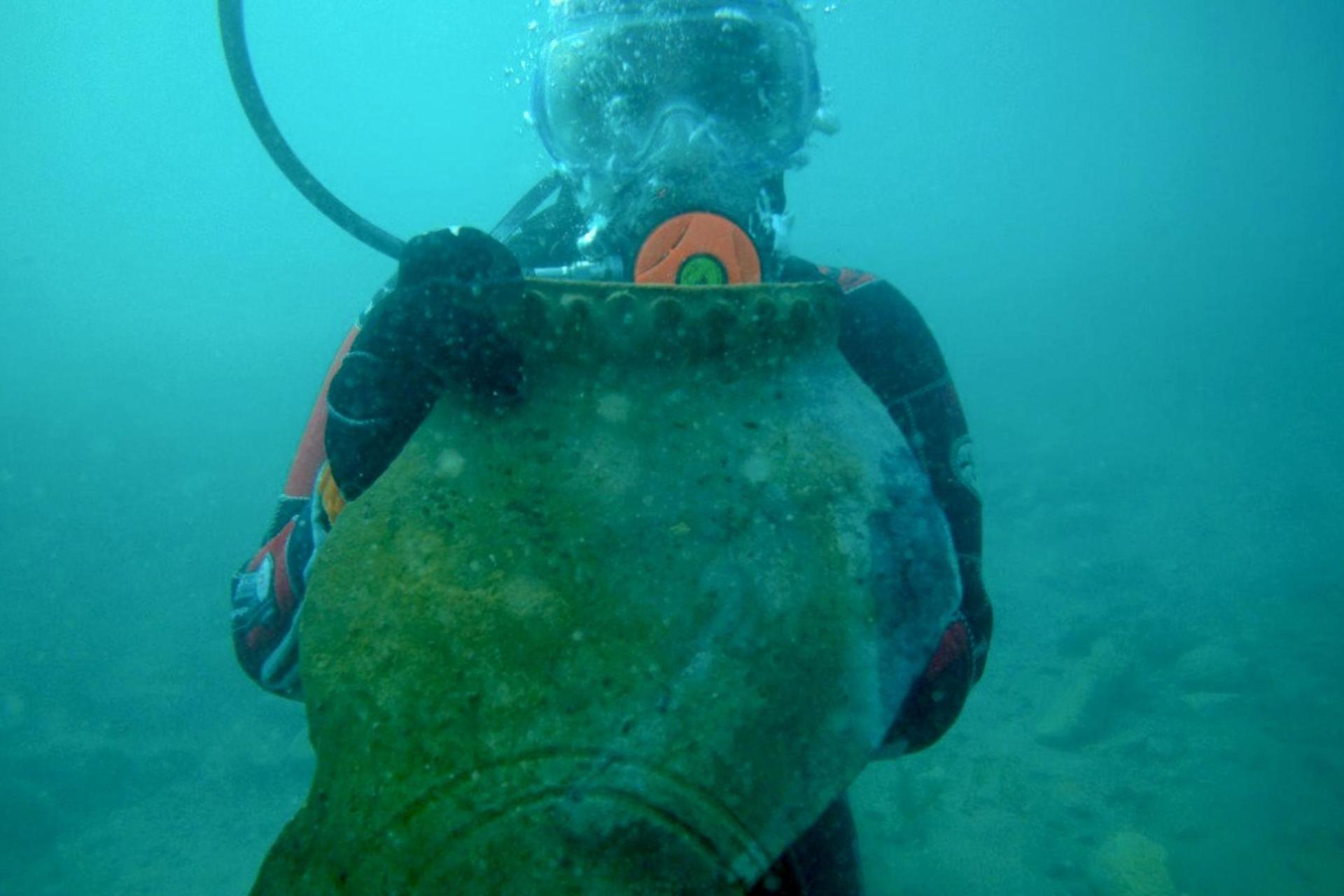 غواص با خمره قرون وسطایی از شهری گمشده در دستش، در اعماق دریاچه‌ای در قرقیزستان.