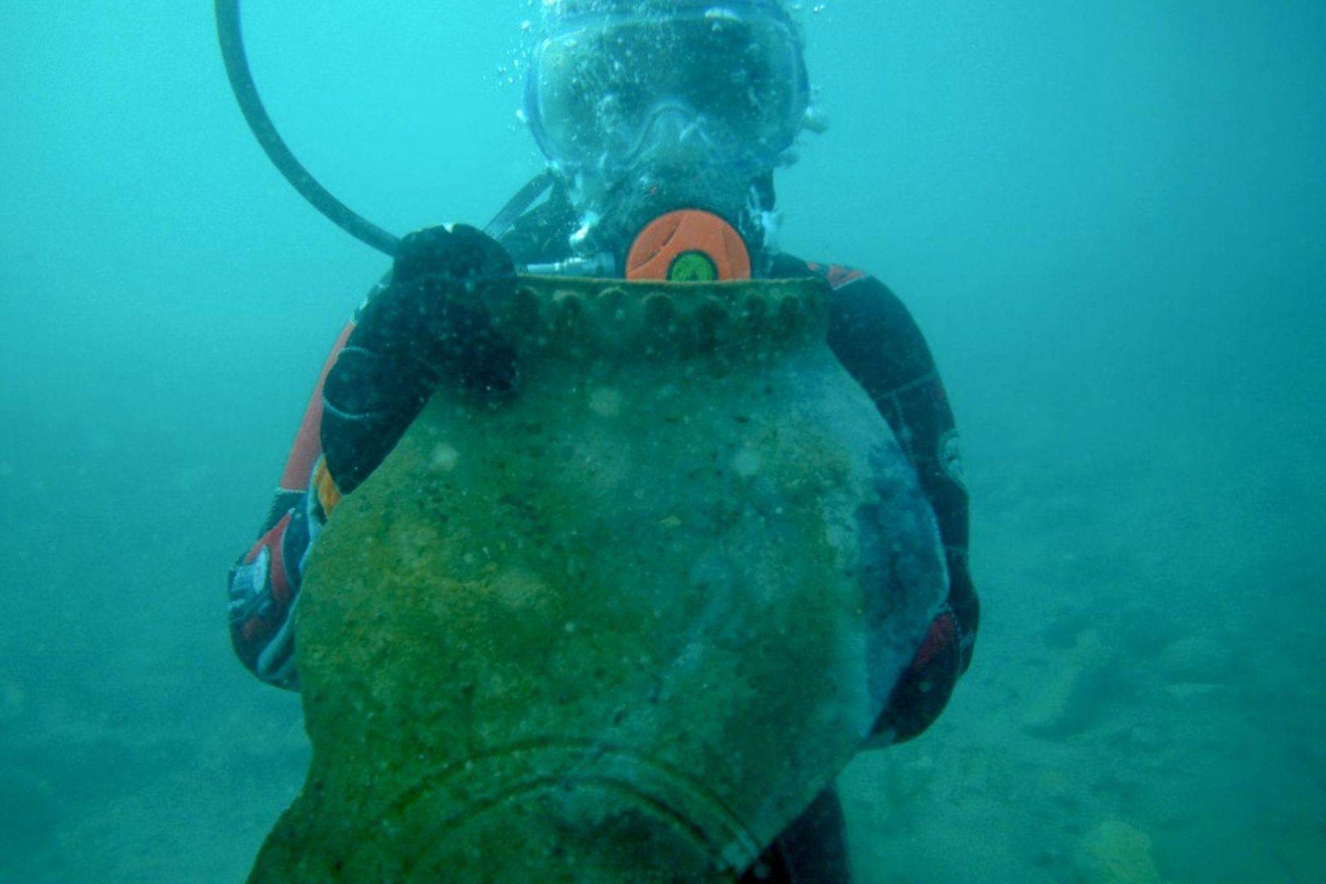 غواص با خمره قرون وسطایی از شهری گمشده در دستش، در اعماق دریاچه‌ای در قرقیزستان.