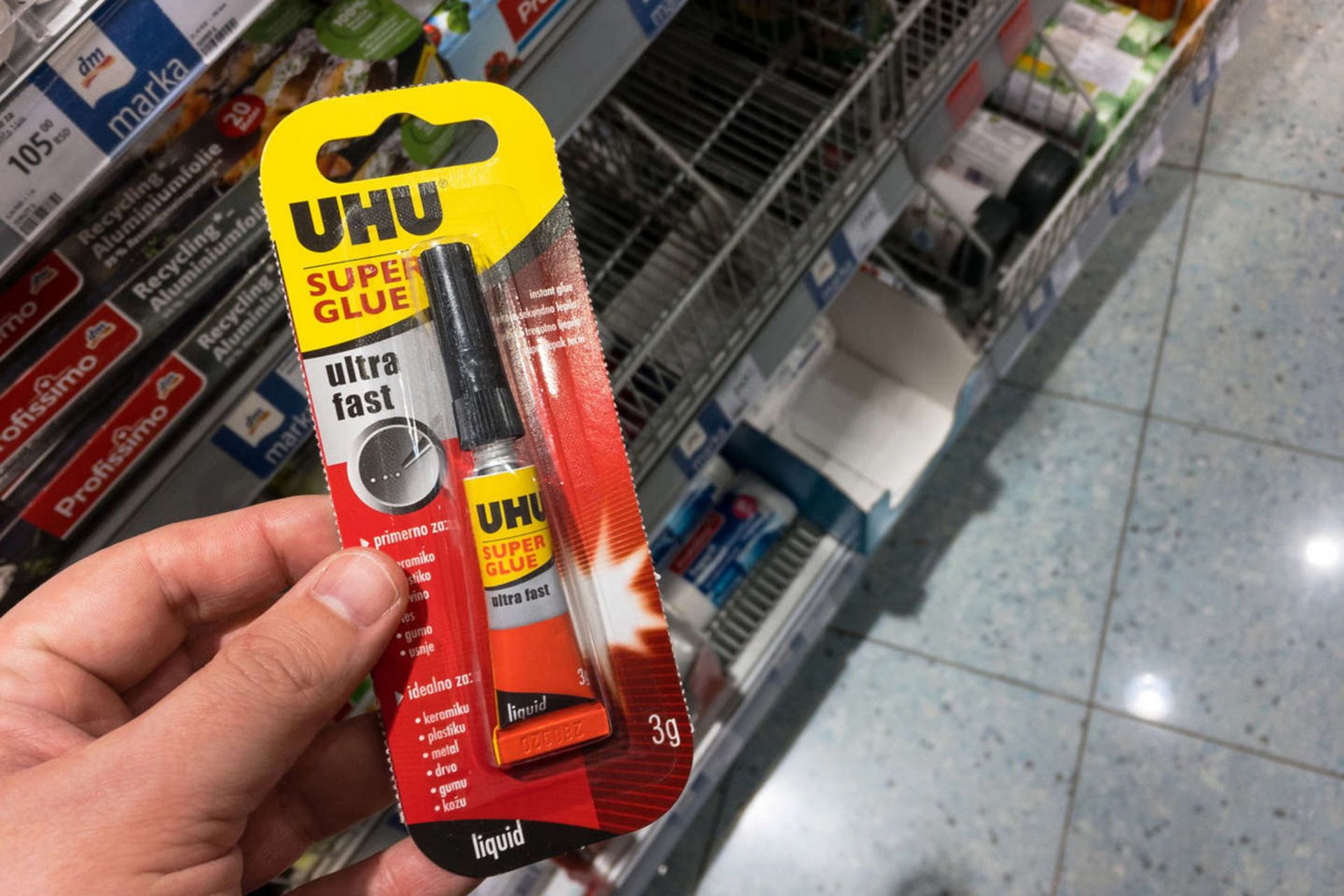 چسب قطره‌ای در دست فردی در فروشگاه