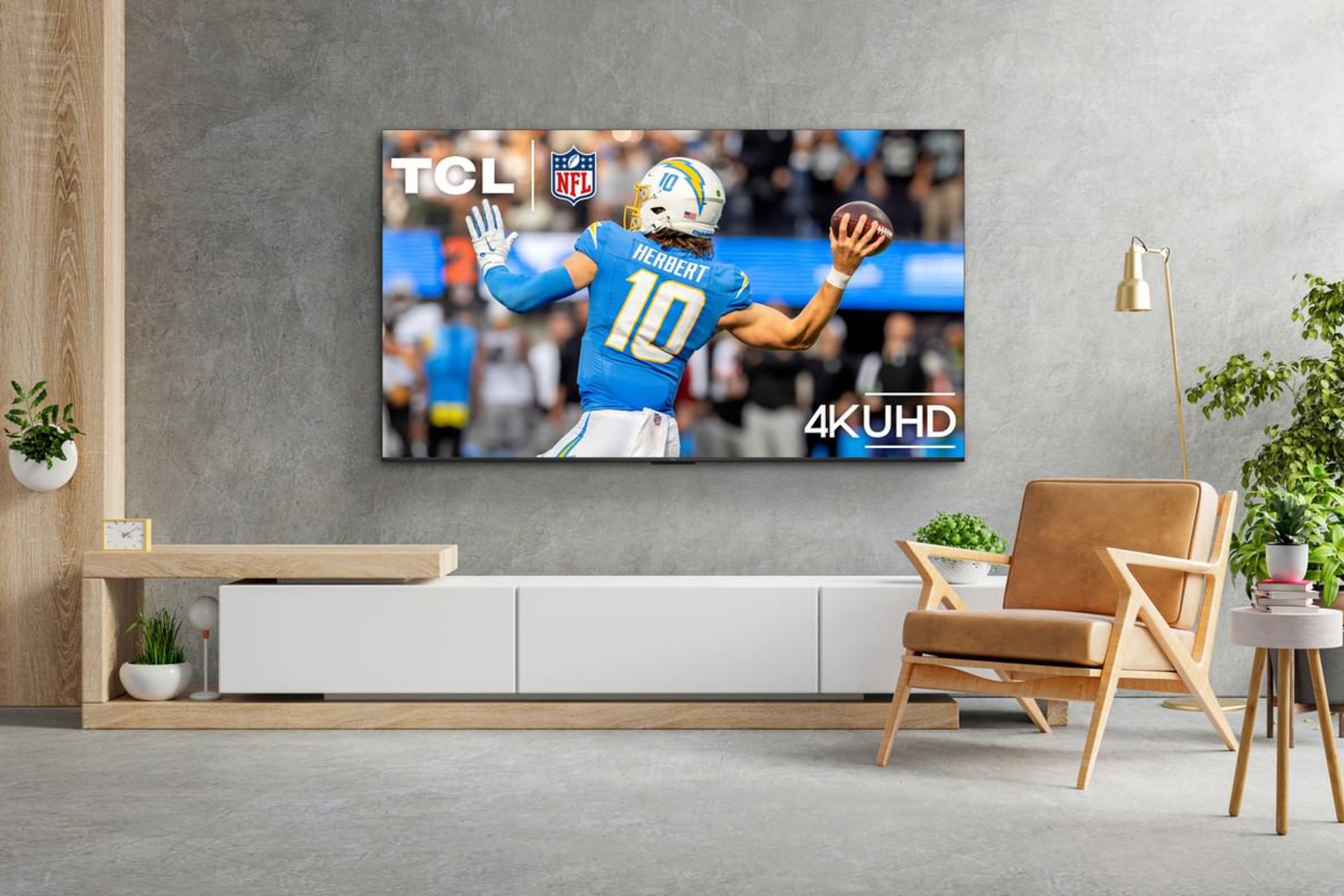 تلویزیون TCL S551G نصب شده روی دیوار یک اتاق مدرن در حال پخش فوتبال آمریکایی