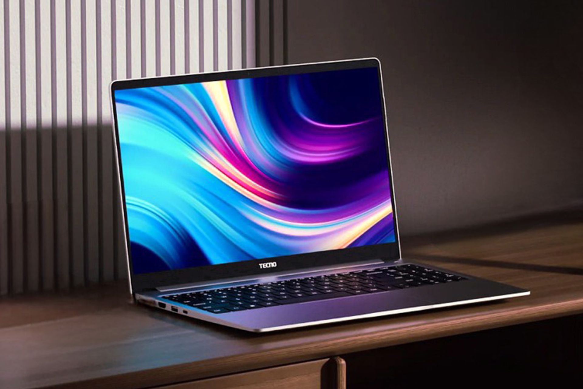 لپ تاپ تکنو مگابوک تی۱ نقرهای از نمای جلو روی میز