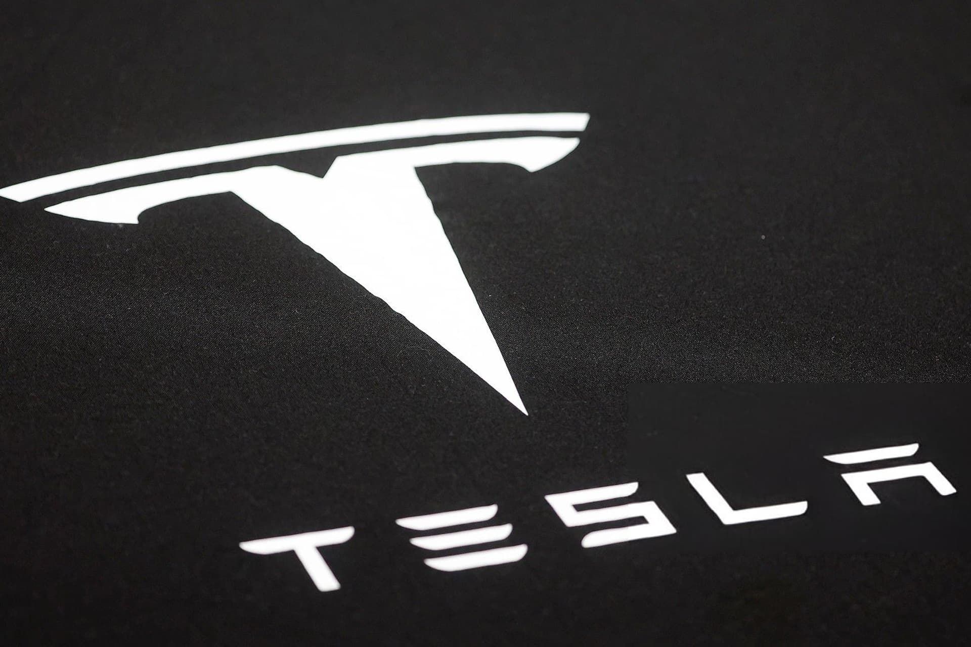 لوگو تسلا / Tesla در پس‌زمینه مشکی به رنگ سفید
