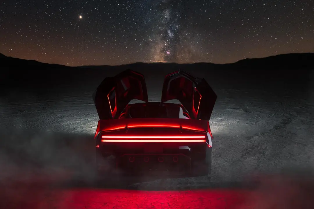 خودرو تسلا رودستر (Tesla Roadster) با درهای بال‌مانند در بیابان زیر آسمان پرستاره