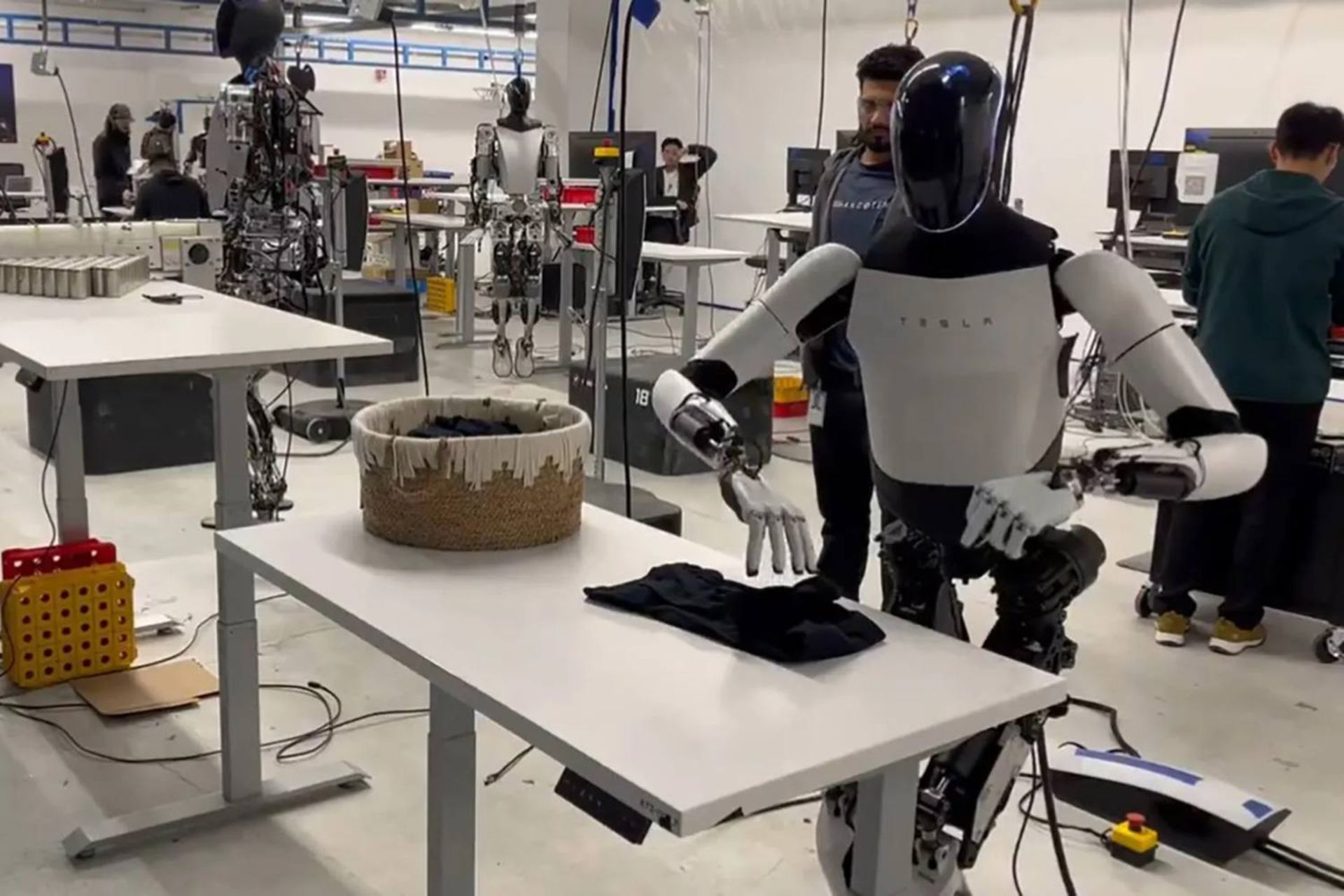 ربات تسلا آپتیموس درحال تا کردن لباس روی میز