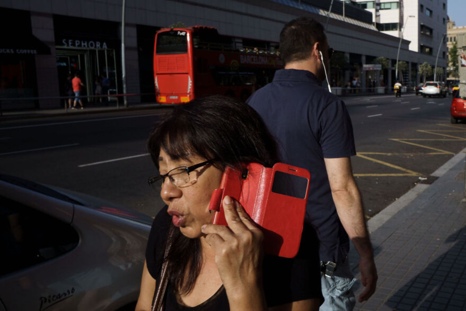 زن در حال صحبت با گوشی با قاب قرمز اتوبوس قرمز