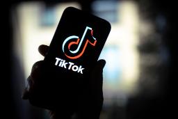 لوگو تیک تاک / TikTok رنگی در دست روی نمایشگر