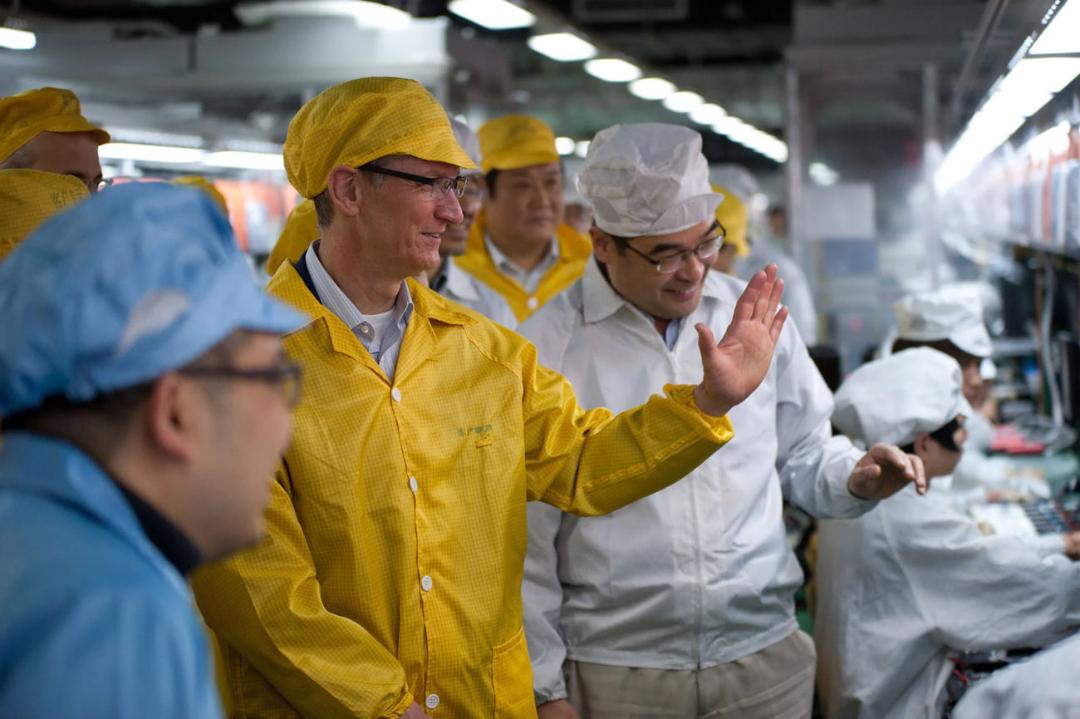 تیم کوک (Tim Cook) در لباس کار زرد رنگ در محیط یک کارخانه تولیدی