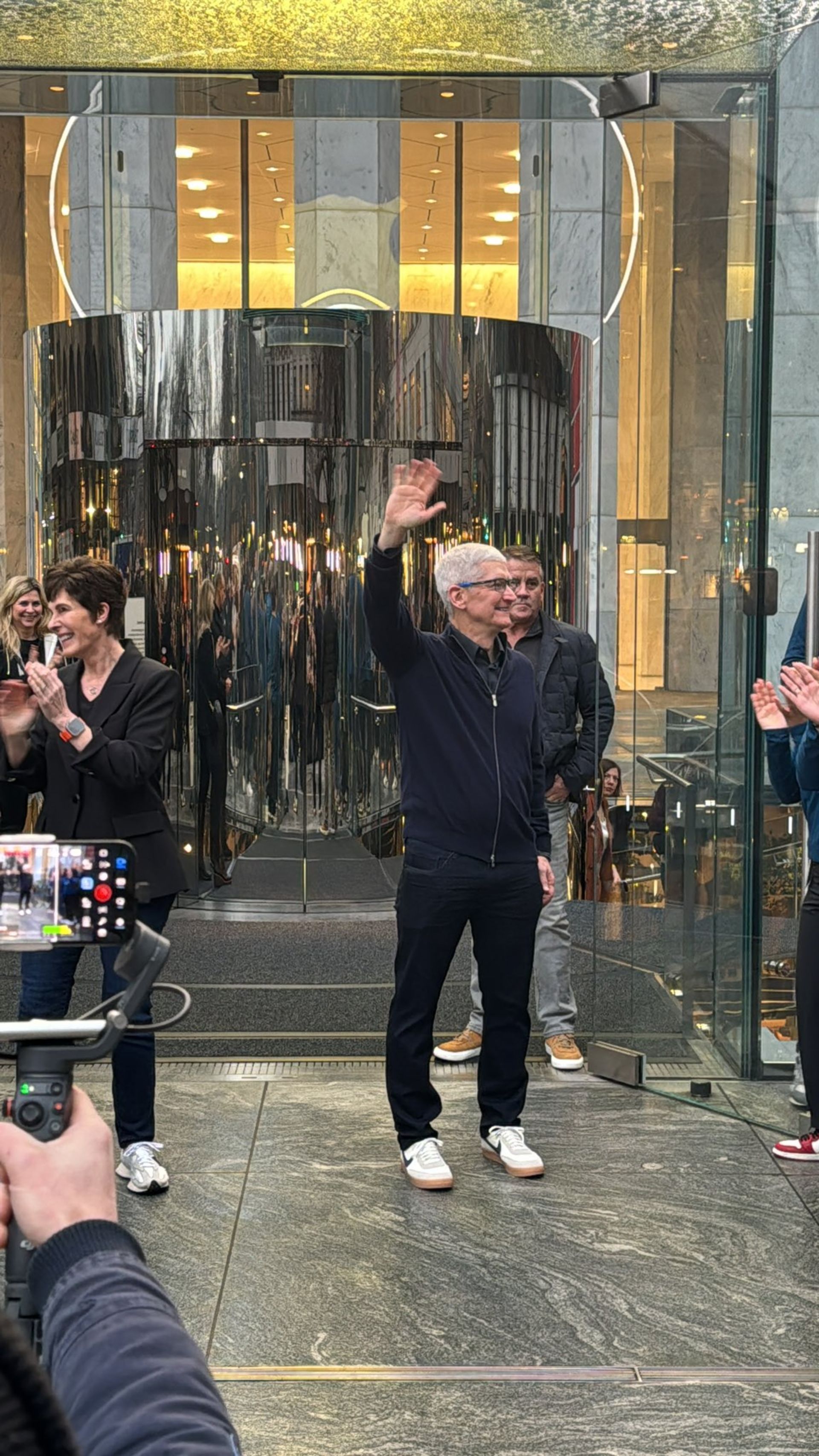 تیم کوک در حال دست تکان دادن در جلوی فروشگاه اپل