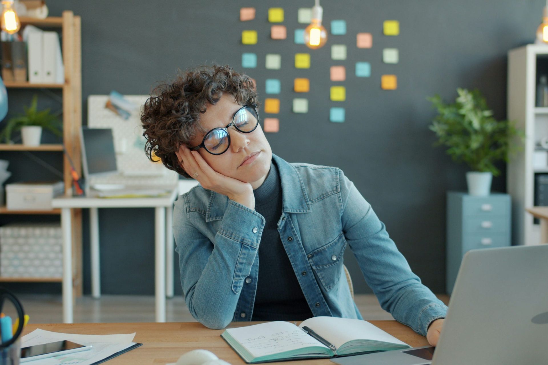 فردی خواب آلود در محل کار پشت سیستم در حال چرت زدن