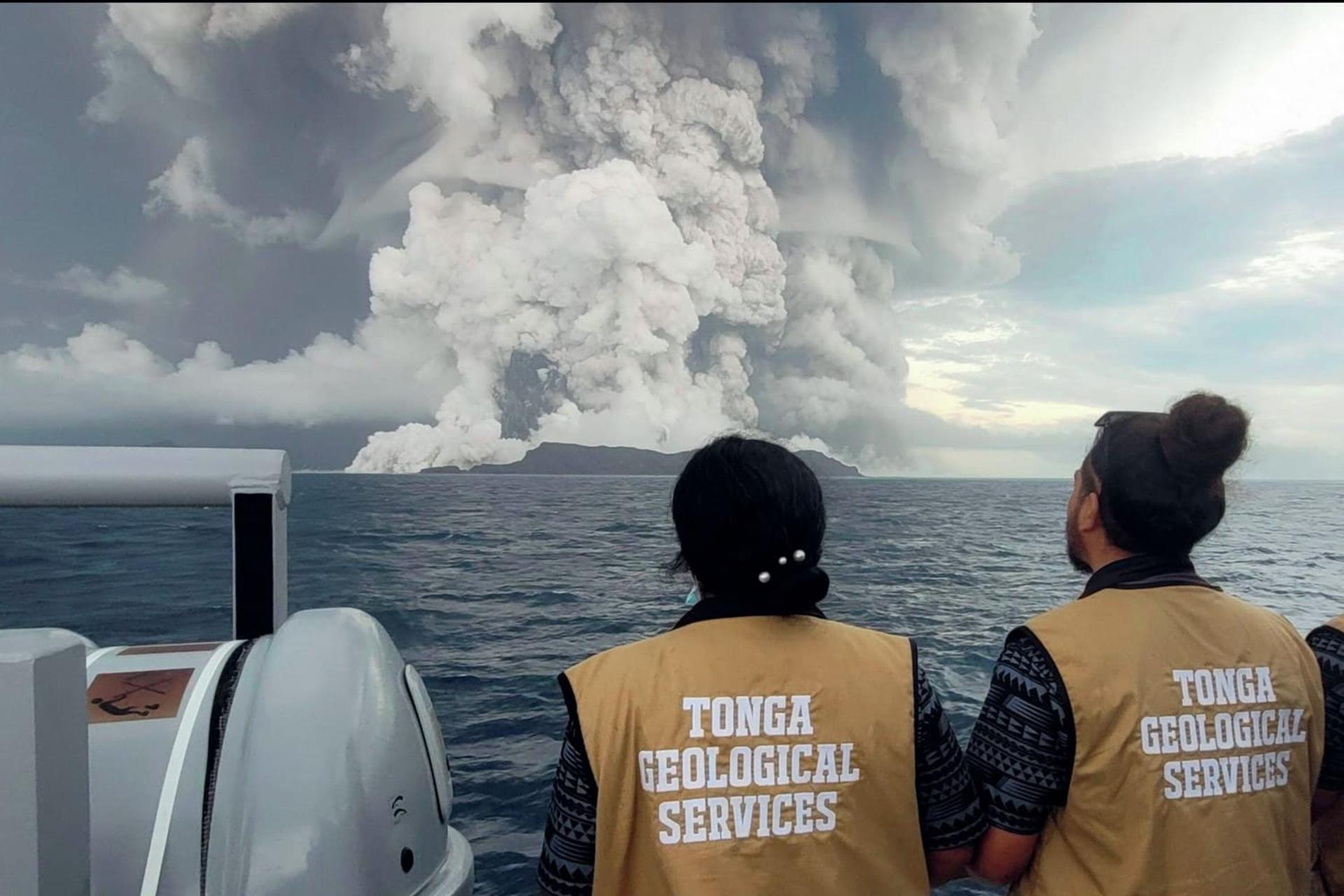 کارکنان خدمات زمین شناسی تونگا فوران آتشفشان را از دور مشاهده می کنند