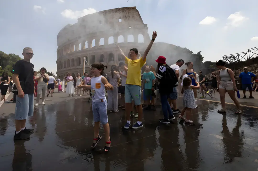 گردشگران در مقابل کولوسئوم (Colosseum) زیر مه پاش‌های آب برای خنک شدن