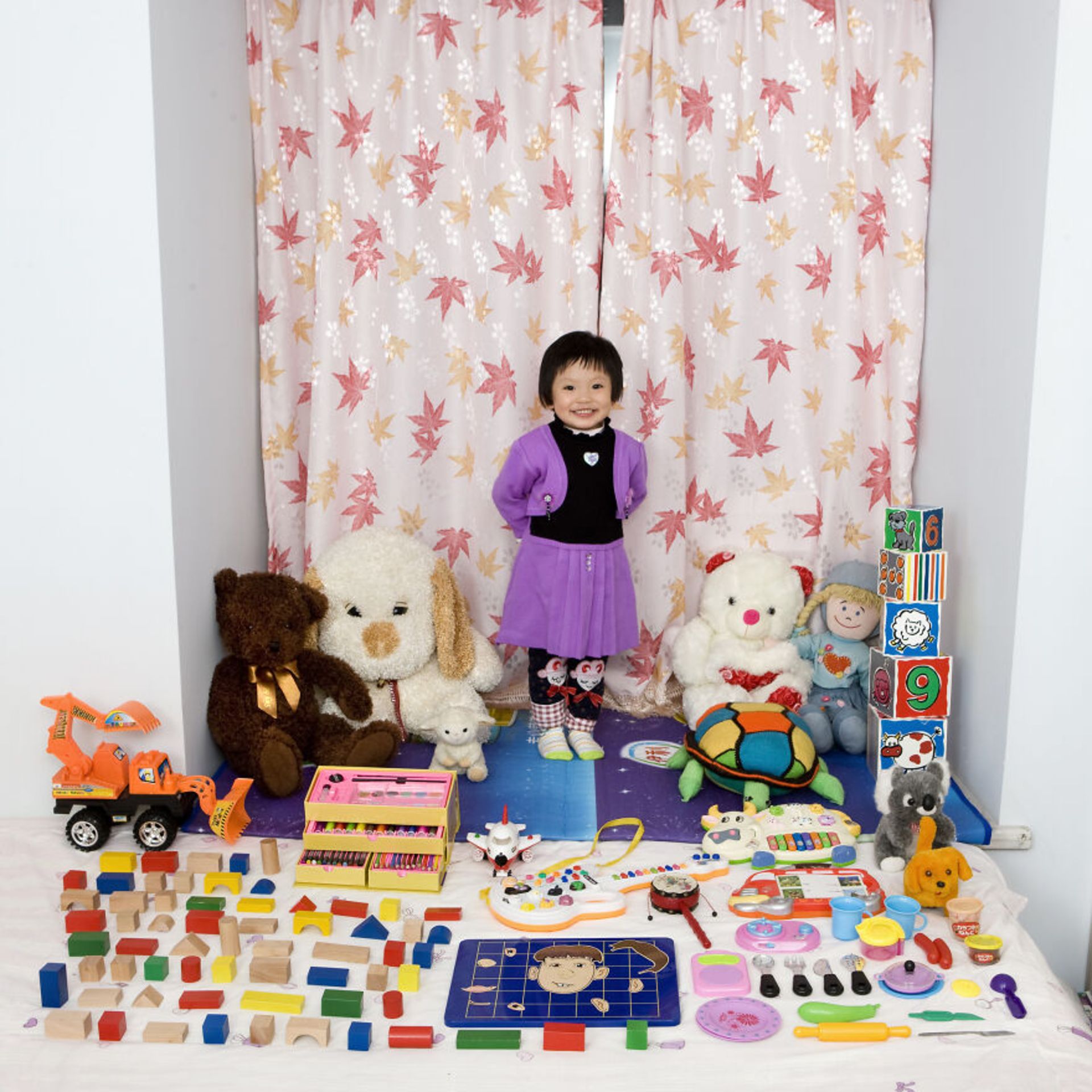 دختر بچه با عروسک و اسباب‌بازی