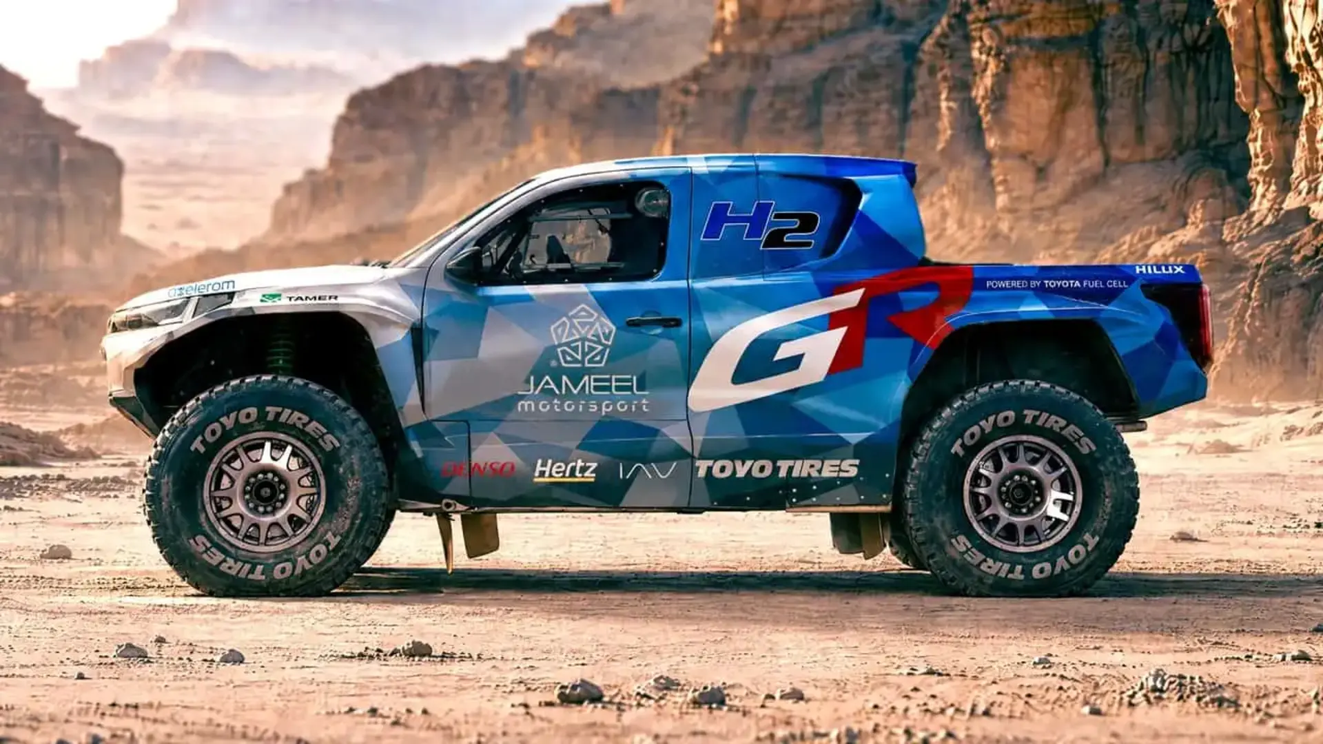 خودروی تویوتا هایلوکس (Toyota Hilux) با طرح گرافیکی آبی و قرمز در بیابان