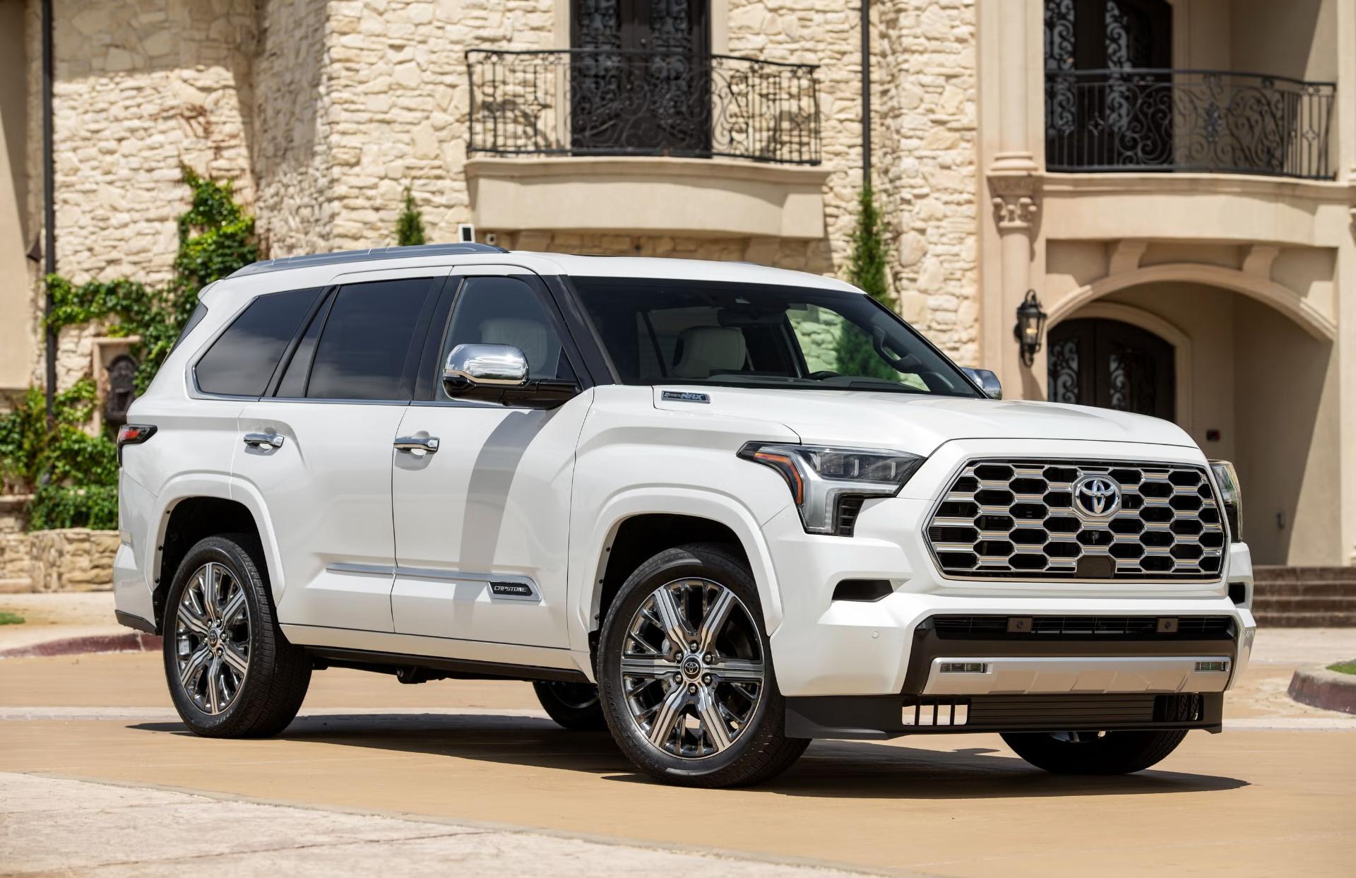 تویوتا سکویا (Toyota Sequoia) سفید رنگ در مقابل یک ساختمان مجلل