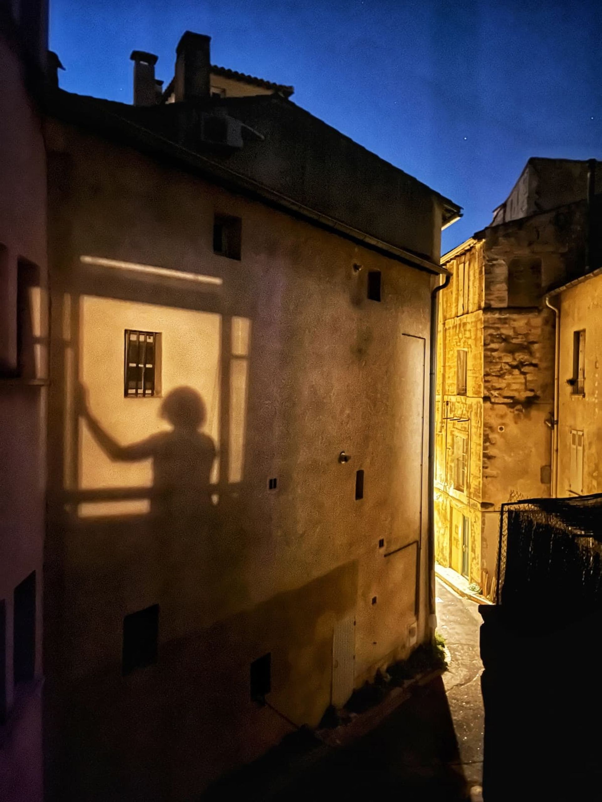 سایه زن روی دیوار بین ساختمان‌ها