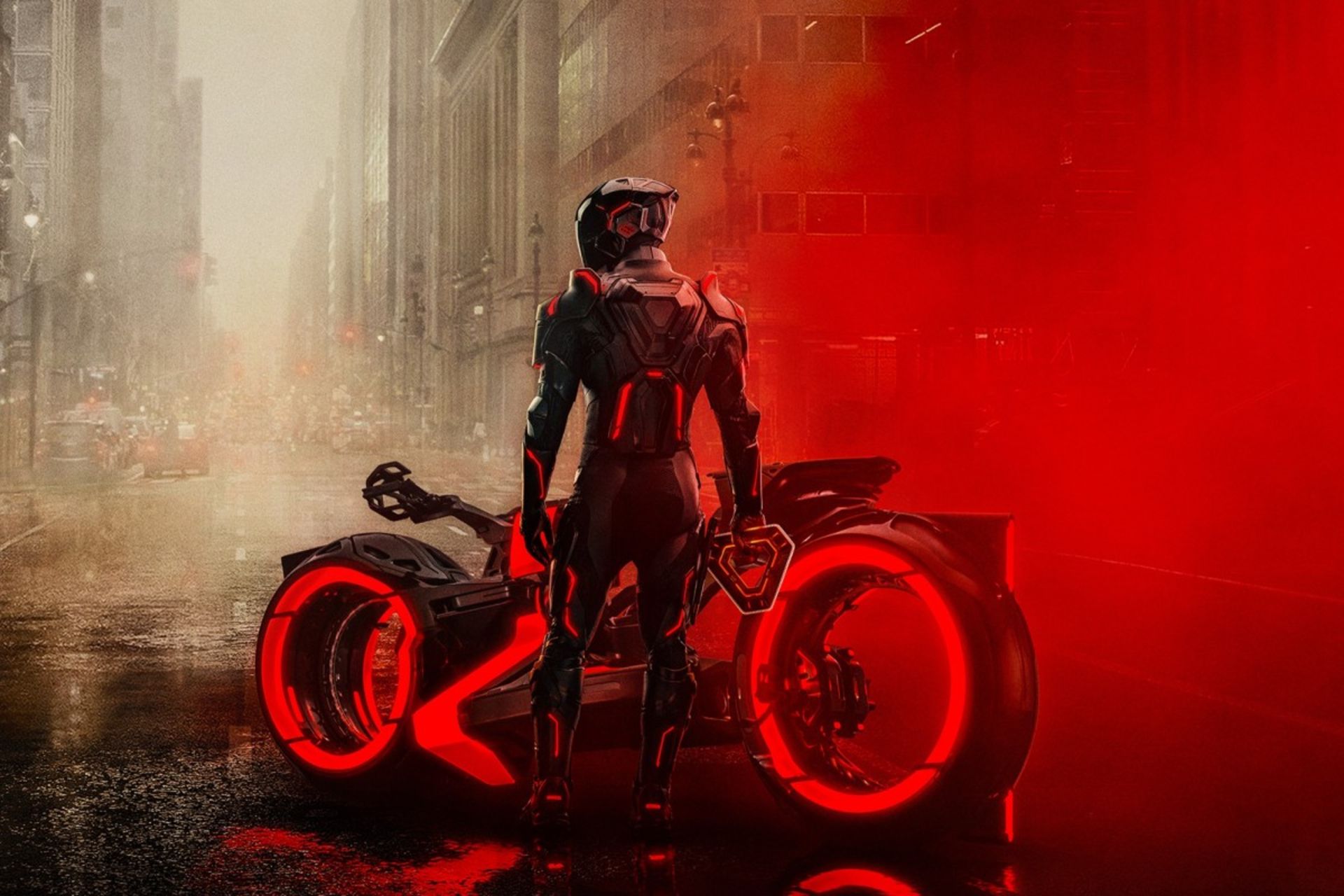 یک مرد موتورسوار کنار موتور در نمای شب در شهر رنگ قرمز
