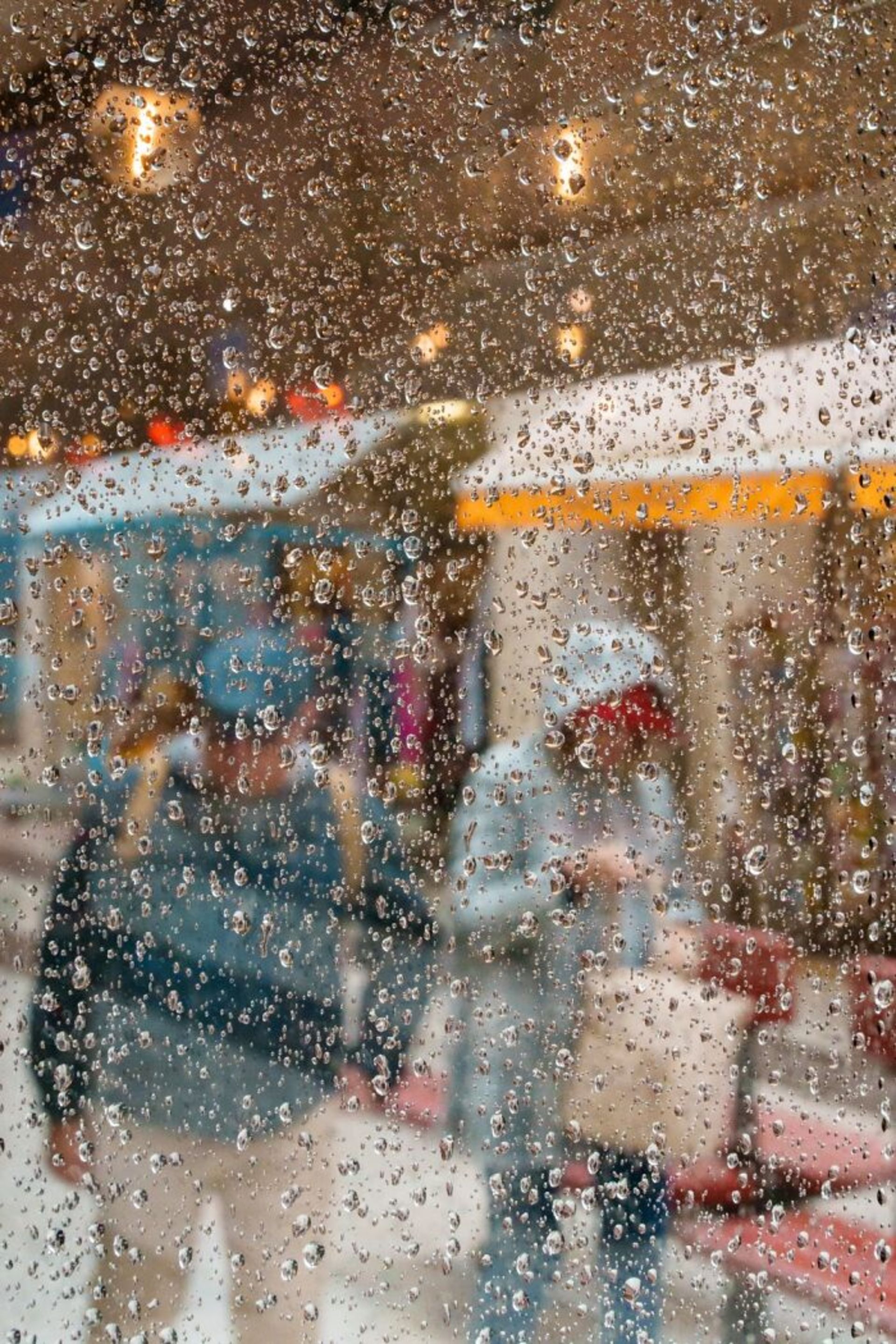 دو عابر پشت پنجره باران زده
