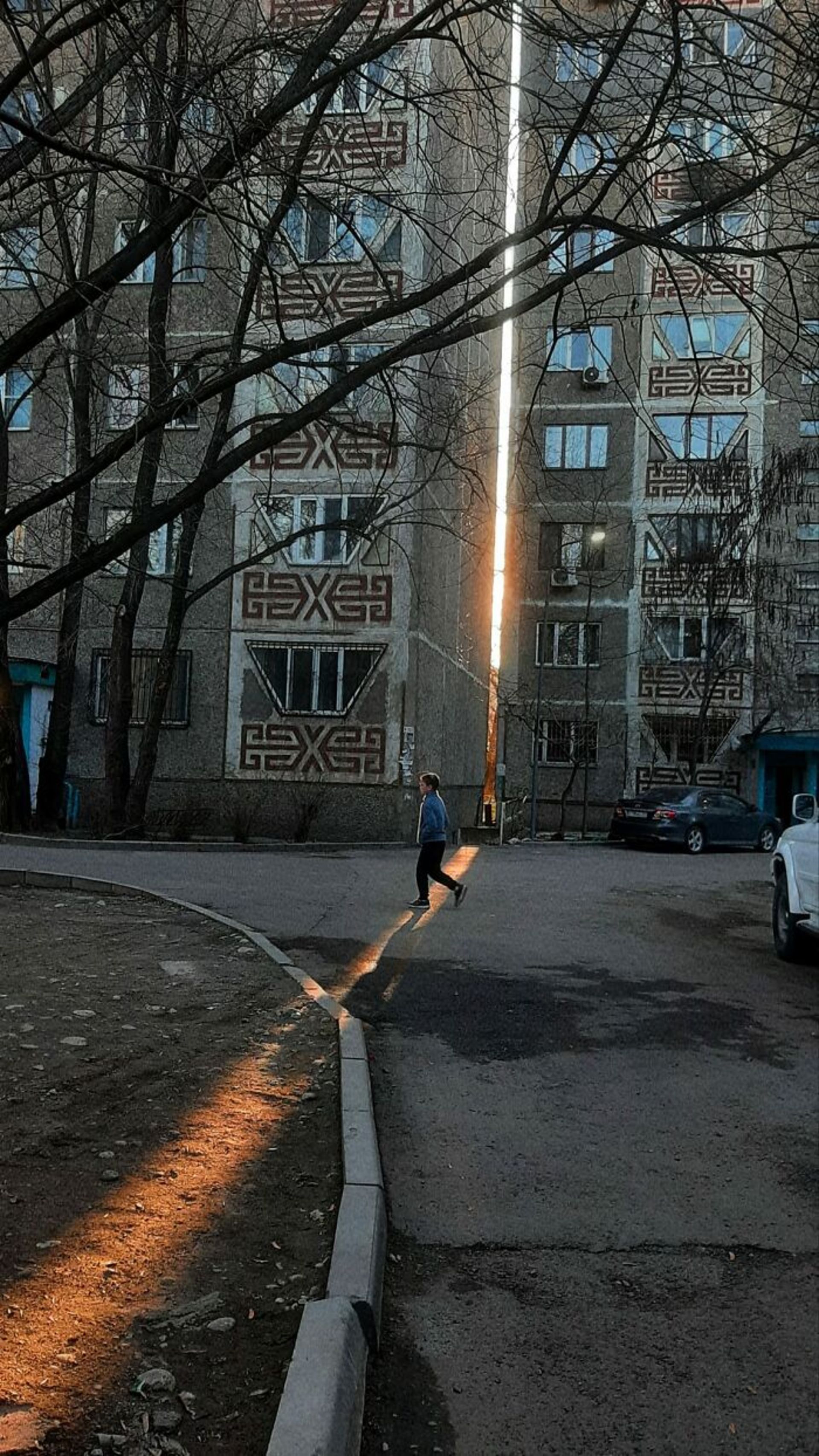 عابر در حال گذر از مقابل ساختمان‌ها