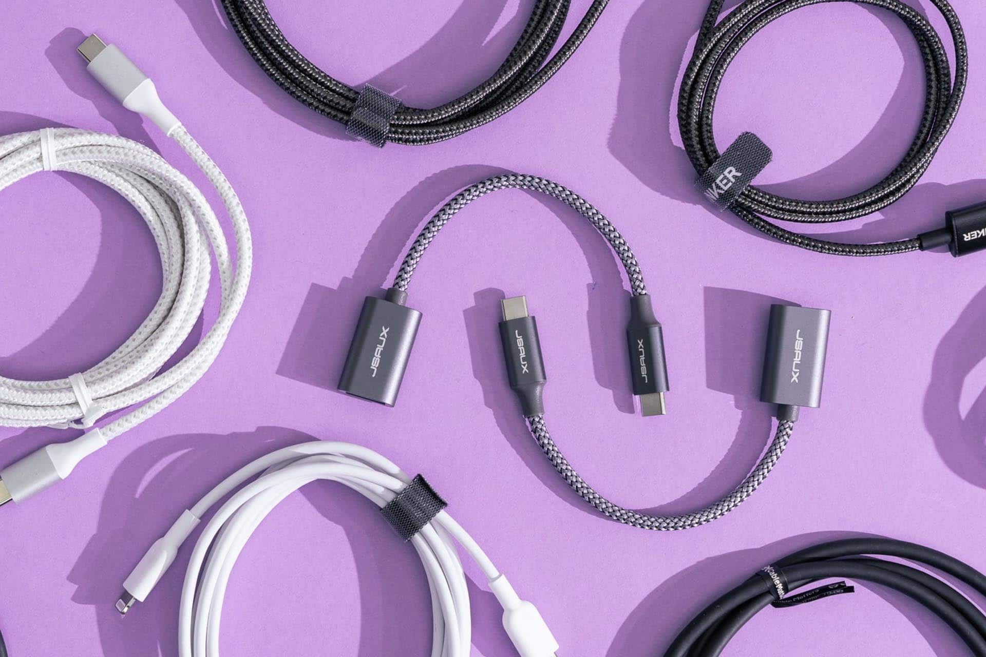 تعدادی کابل یو اس بی از انواع مختلف روی یک میز بنفش